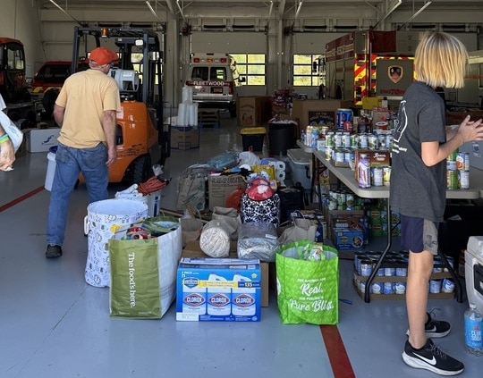 Ashe County families look through donated supplies the Kraai family has helped drop off at a North Carolina fire station after Hurricane Helene.