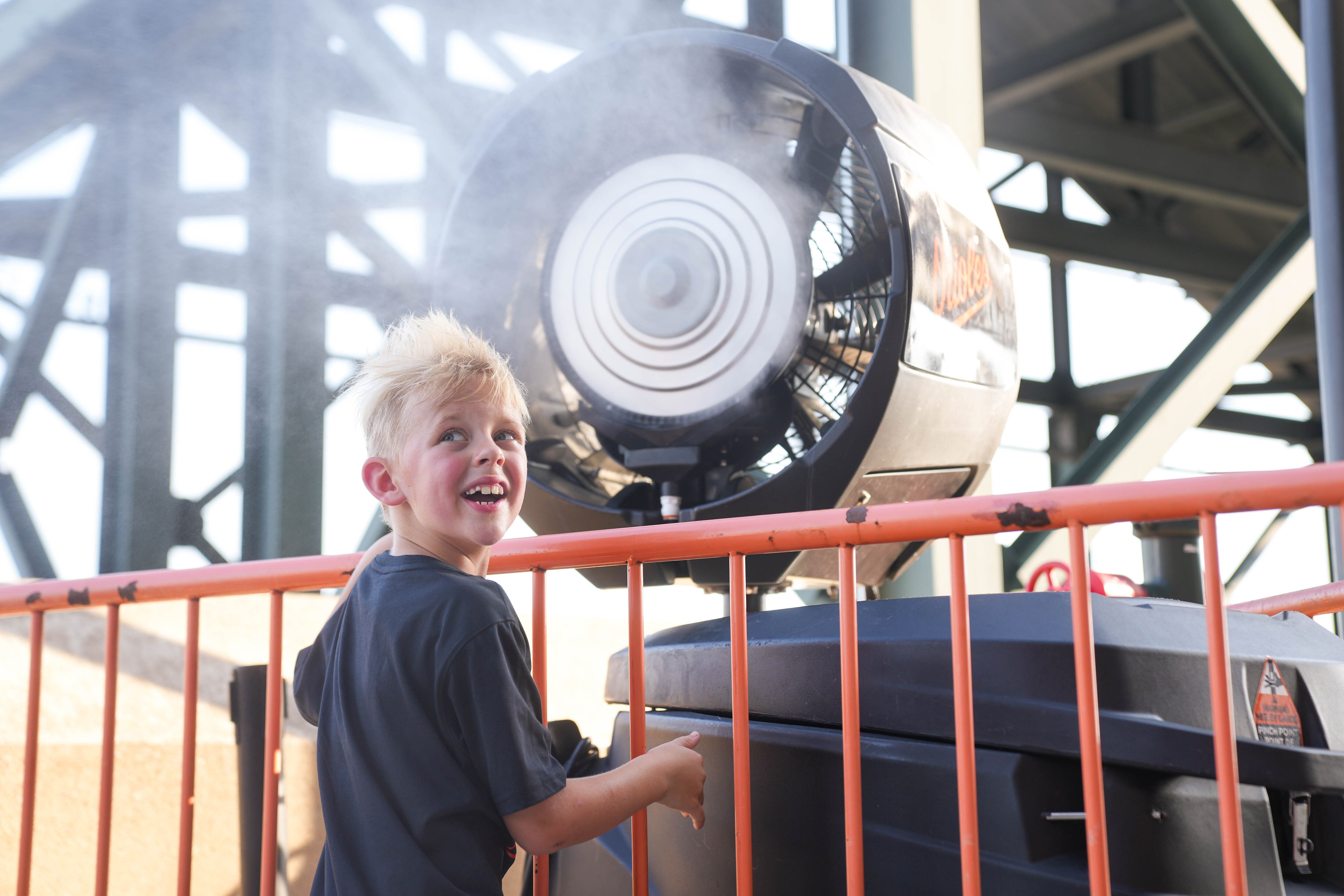 Baltimore Orioles fan Solomon Baker, 8, uses a misting station to cool off at his first-ever game.