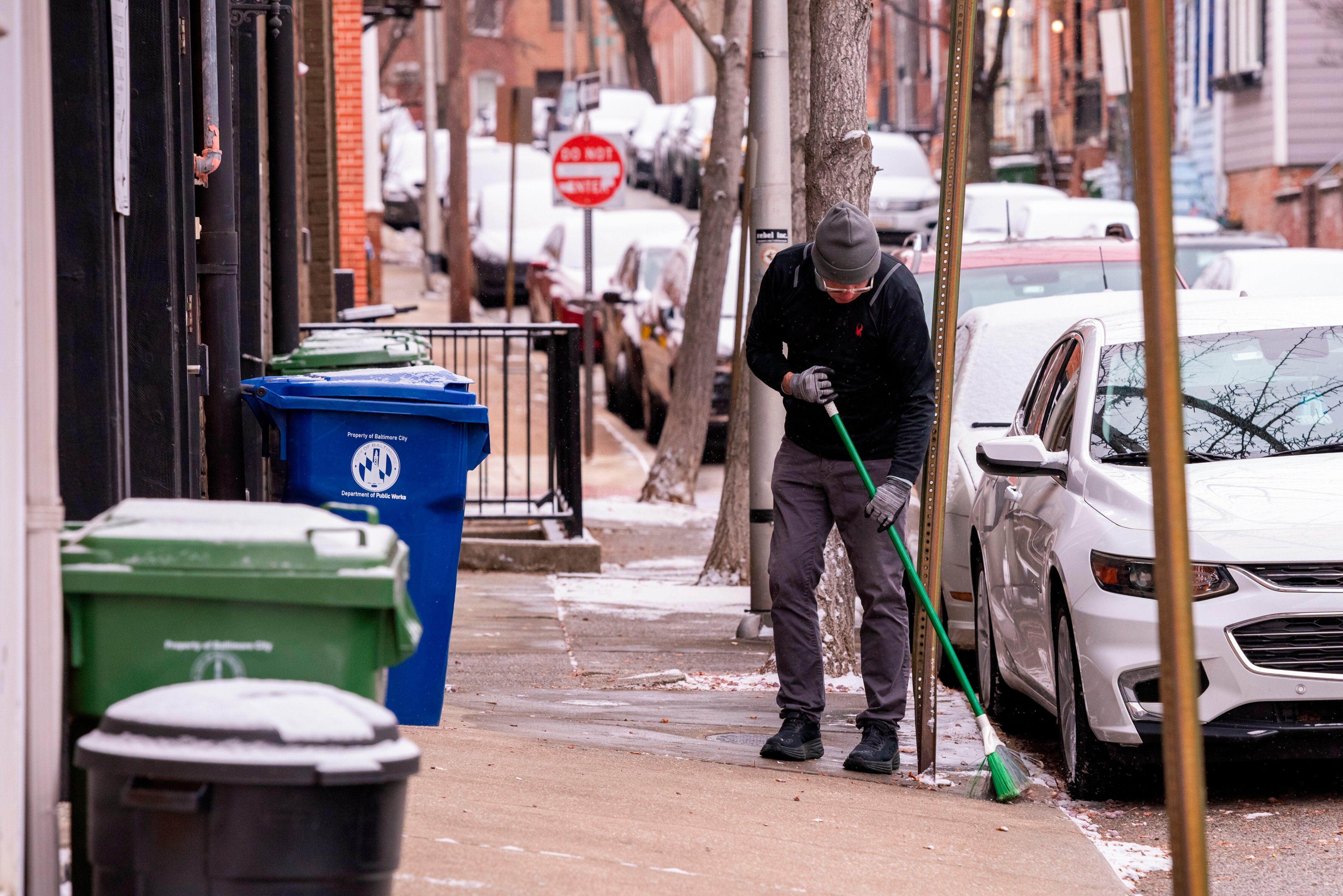 Doug Clemens sweeps snow from the sidewalk in Baltimore’s Federal Hill.