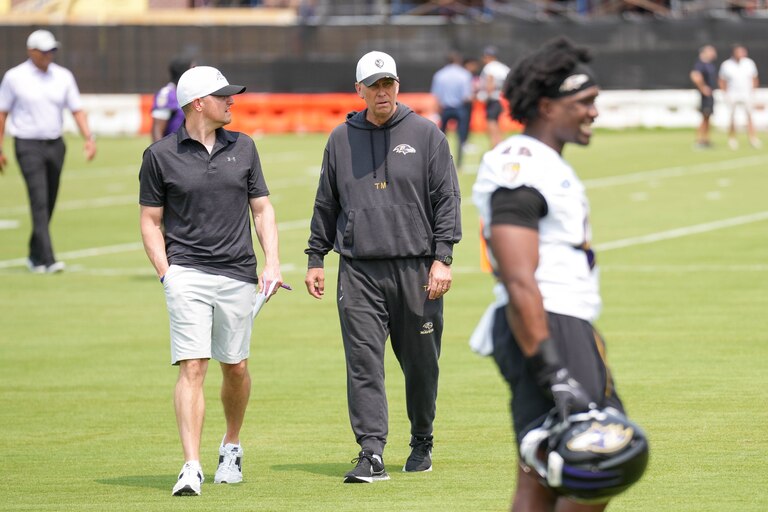 Baltimore Ravens offensive coordinator Todd Monken, center, walks to the podium area of the field to take questions from reporters following the team’s organized team activities at the Under Armour Performance Center in Owings Mills, Md. on Tuesday, June 3, 2025.