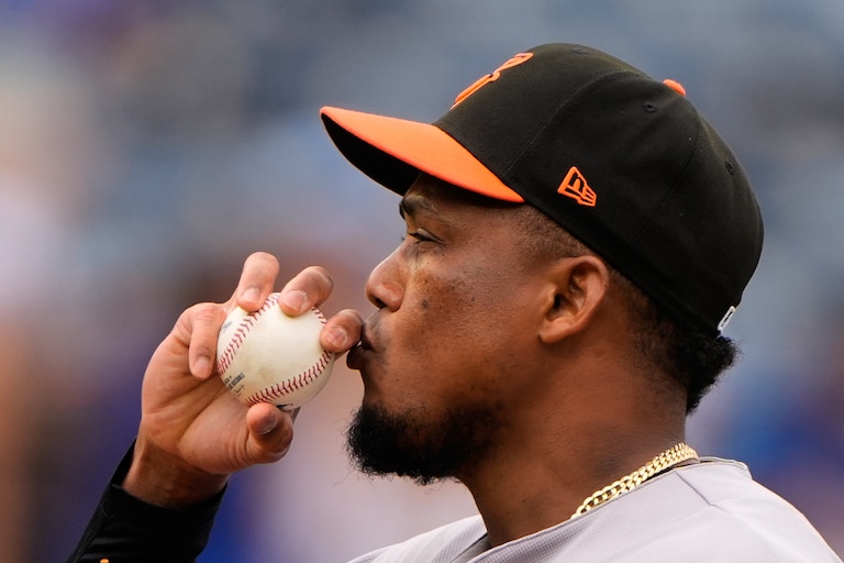 Baltimore Orioles relief pitcher Yennier Cano kisses a baseball before throwing during the sixth inning of a baseball game against the Kansas City Royals, Wednesday, April 22, 2026, in Kansas City, Mo.