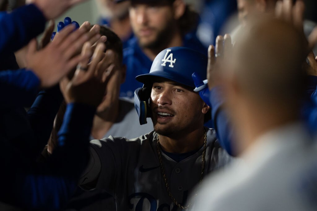 Kolten Wong, #25 of the Los Angeles Dodgers, is congratulated by teammates in the dugout after hitting an RBI sacrifice fly. (Photo by Stephen Brashear/Getty Images)