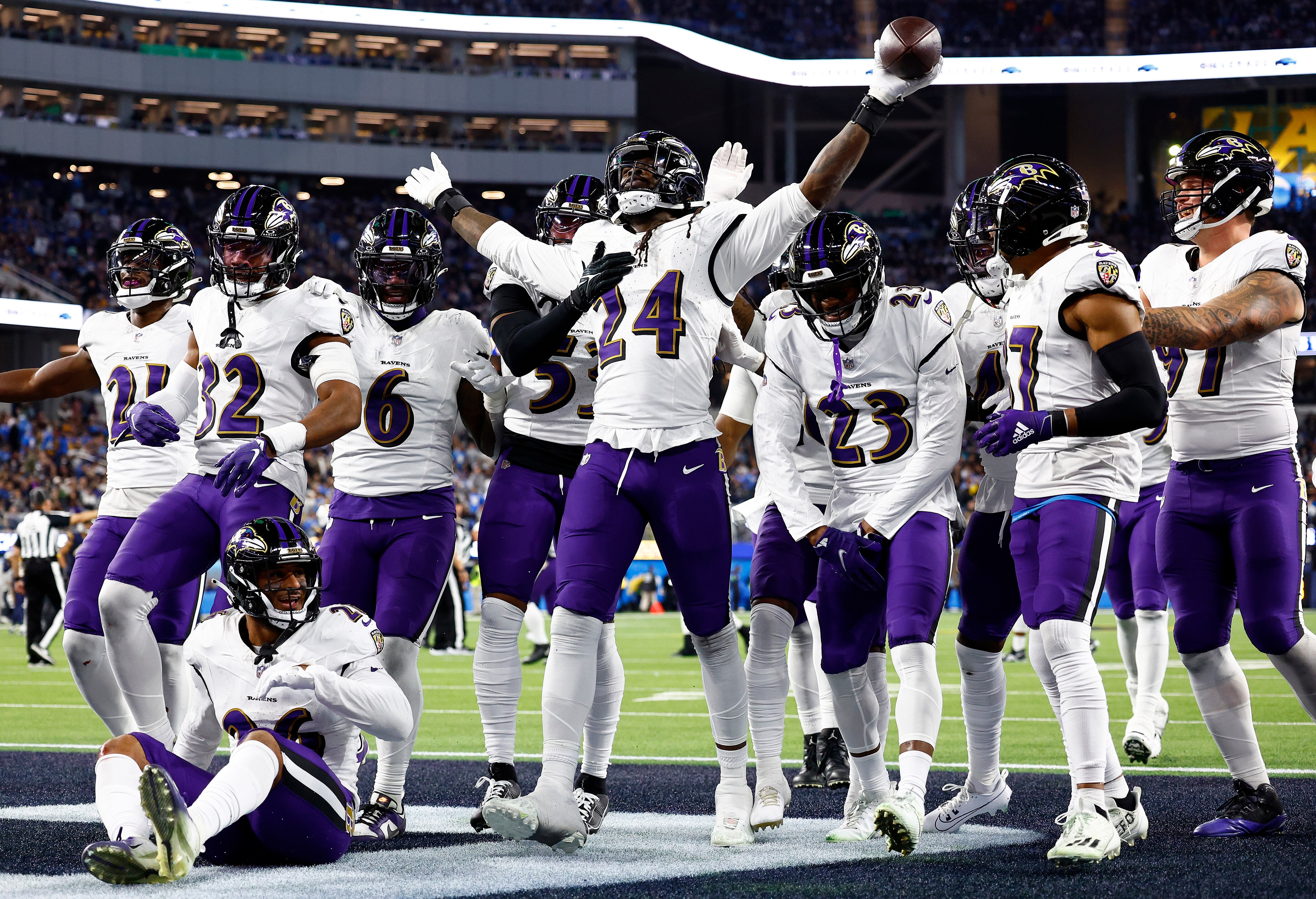 The Ravens' defense gathers around Jadeveon Clowney after his key strip-sack and fumble recovery Sunday night during the fourth quarter at Los Angeles.