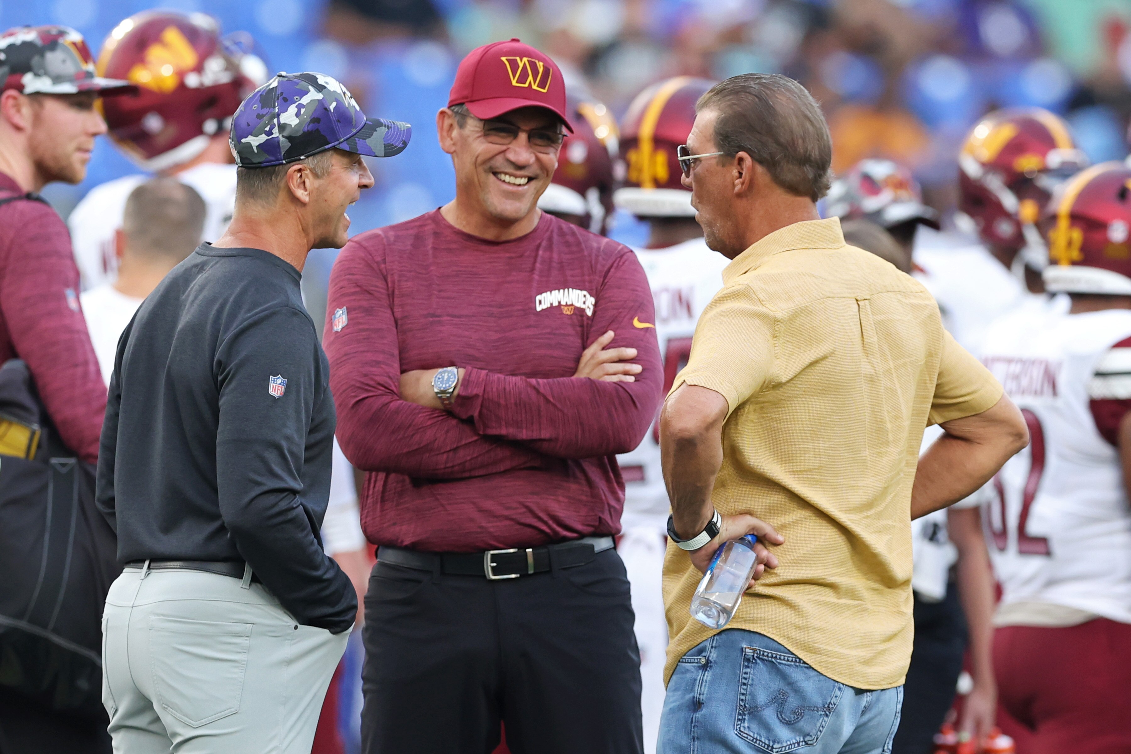 Head coach John Harbaugh (left) of the Ravens talks with head coach Ron Rivera (center) of the Commanders and Ravens owner Steve Bisciotti before a preseason game last year. Bisciotti paid $275 million for 49% of the franchise in 1999.