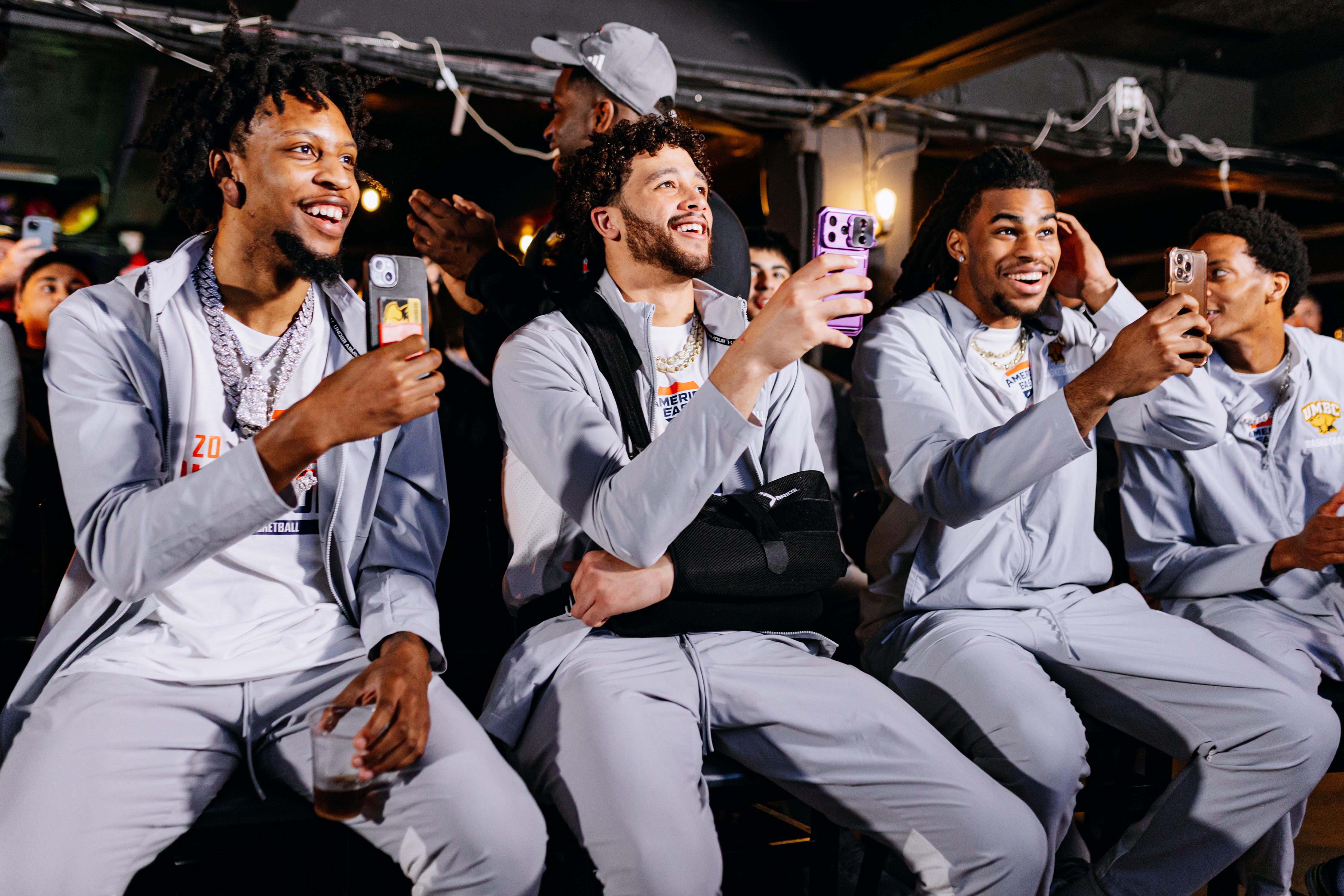 UMBC players, from left, senior DJ Armstrong Jr., junior Daylon Dickerson, sophomore Timothy Eze and grad student Paul Greene cheer the announcement of the Retrievers’ selection to the NCAA First Four.
