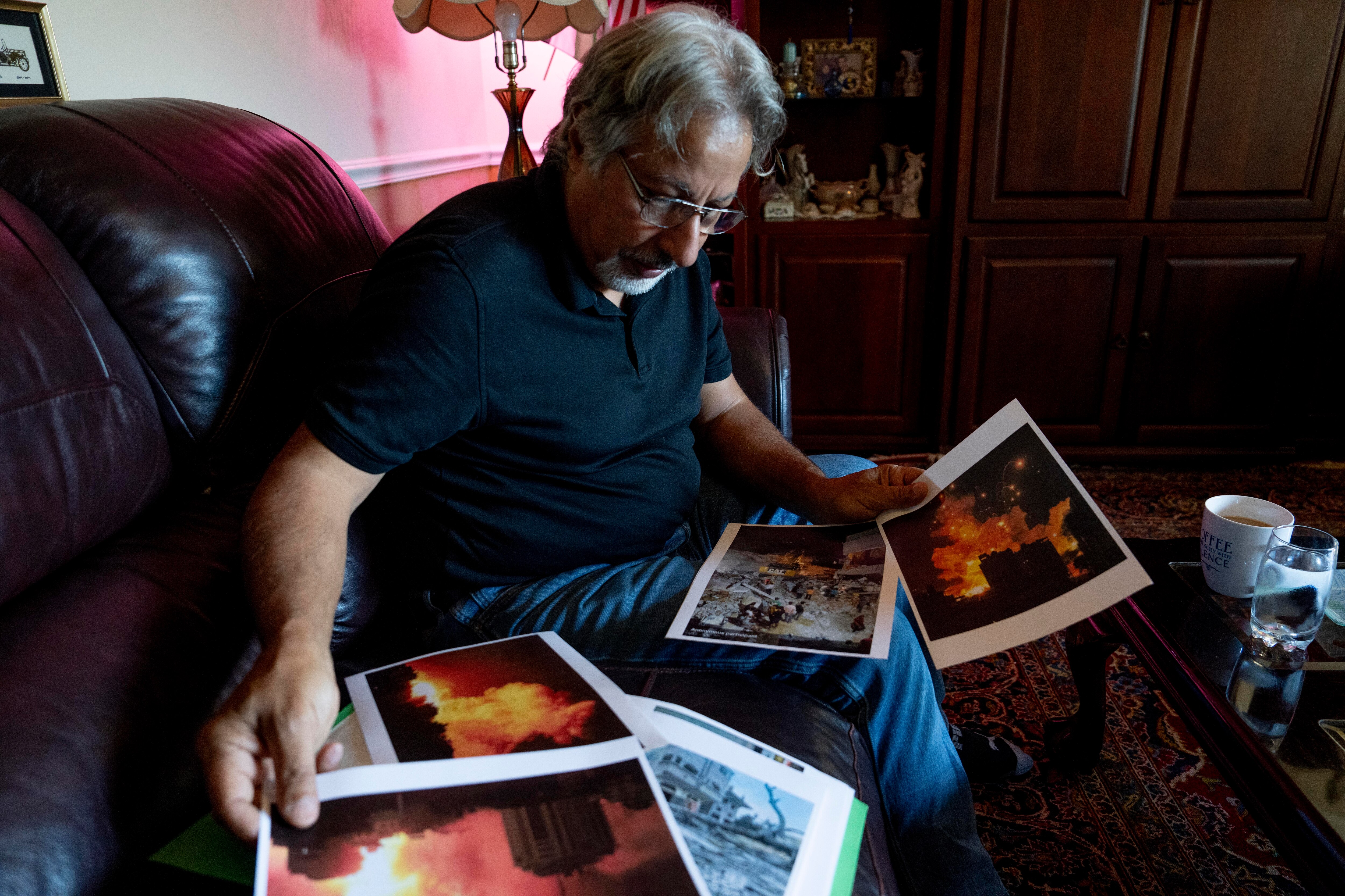 Aref Ramadan looks at photos of his deceased relatives who were victims of attacks on Gaza last week. Ramadan says his family uses social media to communicate but service is sparse. He has not heard from his living relatives in over three days.