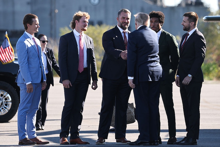 President Donald Trump greets members of the Baltimore Ravens, from left to right, kicker Tyler Loop, punter Ryan Eckley, long snapper Nick Moore and cornerback Marlon Humphrey, and political consultant Alex Bruesewitz as he arrives to speak at Tradepoint Atlantic on Tuesday.