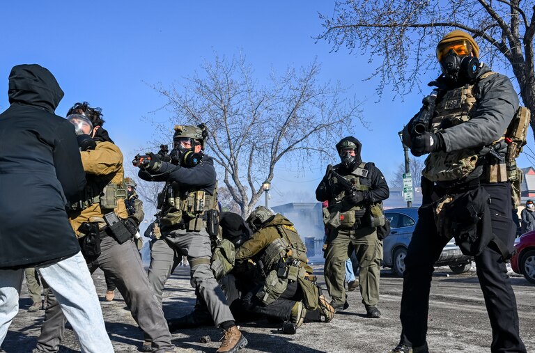 A person is tackled by a federal agent amid protests following a shooting on January 24, 2026 in Minneapolis, Minnesota. Federal agents shot and killed a protestor amid a scuffle to arrest him. The Trump administration has sent a reported 3,000 federal agents into the area, with more on the way, as they make a push to arrest undocumented immigrants in the region.