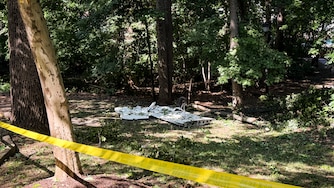 SUNDAY, JUNE 21, 2026 - A portion of the wreckage can be seen at the site where a plane crashed in the woods near a residential area and playground off of Scarlett Oak Court in Bowie on Saturday night.