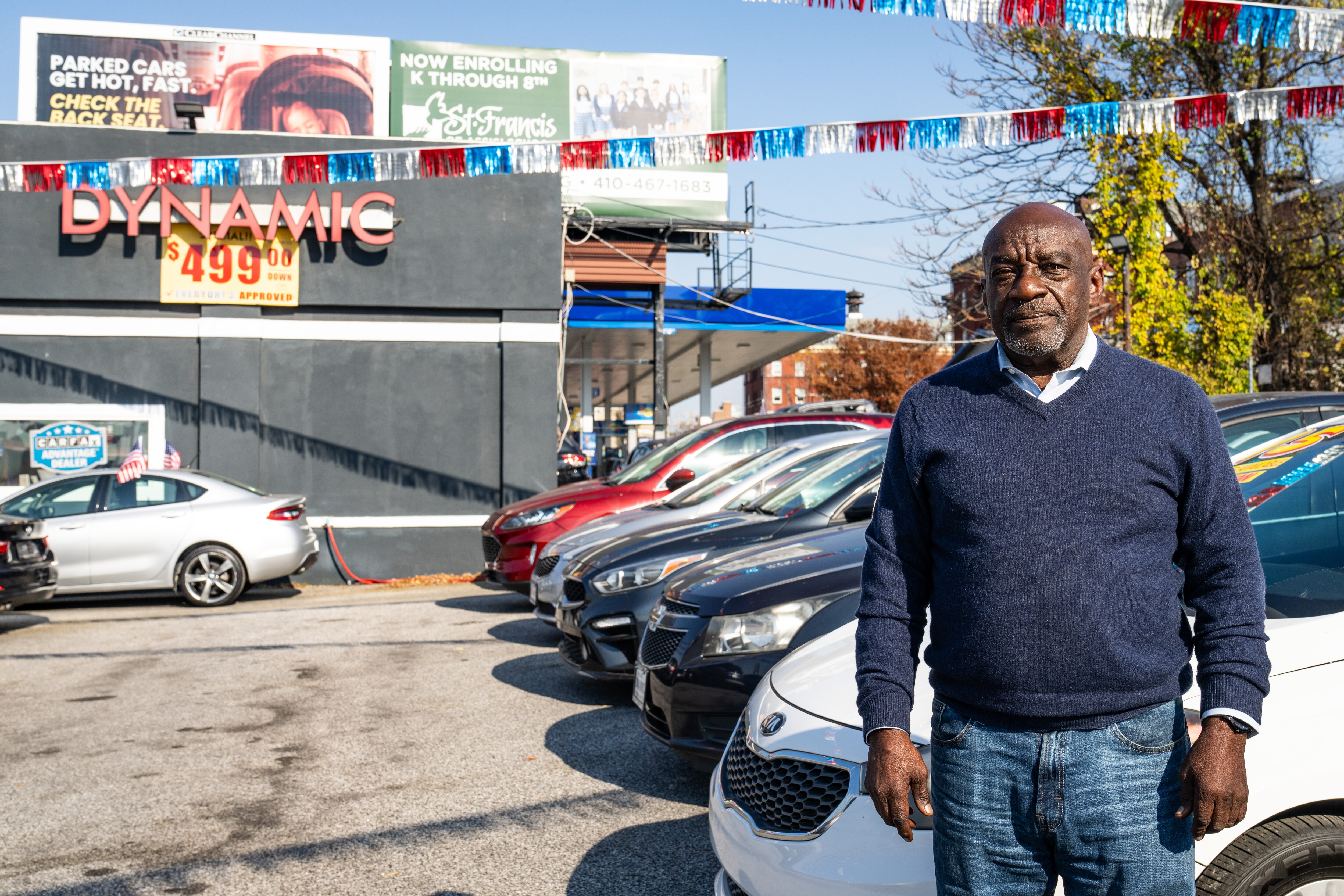 Carl Moore, a salesman at used car dealership Dynamic Cars Inc., poses for a portrait at the company’s Old Goucher location on Thursday, Nov. 9, 2023.