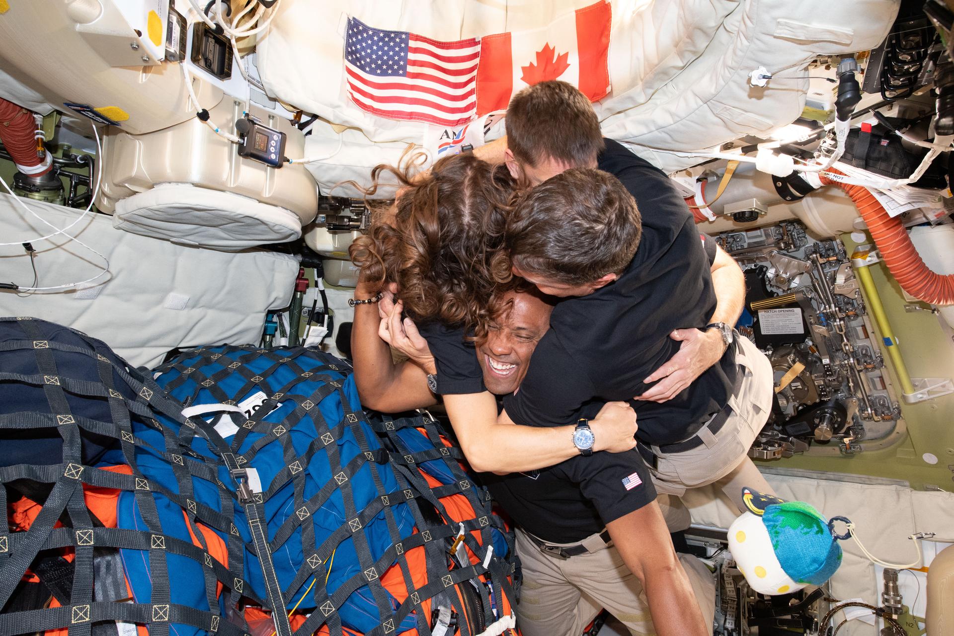 (April 7, 2026) – The Artemis II crew – (clockwise from left) Mission Specialist Christina Koch, Mission Specialist Jeremy Hansen, Commander Reid Wiseman, and Pilot Victor Glover – take time out for a group hug inside the Orion spacecraft on their way home. Following a swing around the far side of the Moon on April 6, 2026, the crew exited the lunar sphere of influence (the point at which the Moon's gravity has a stronger pull on Orion than the Earth's) on April 7, and are headed back to Earth for a splashdown in the Pacific Ocean on April 10. The crew was selected in April 2023, and have been training together for their mission for the past three years.