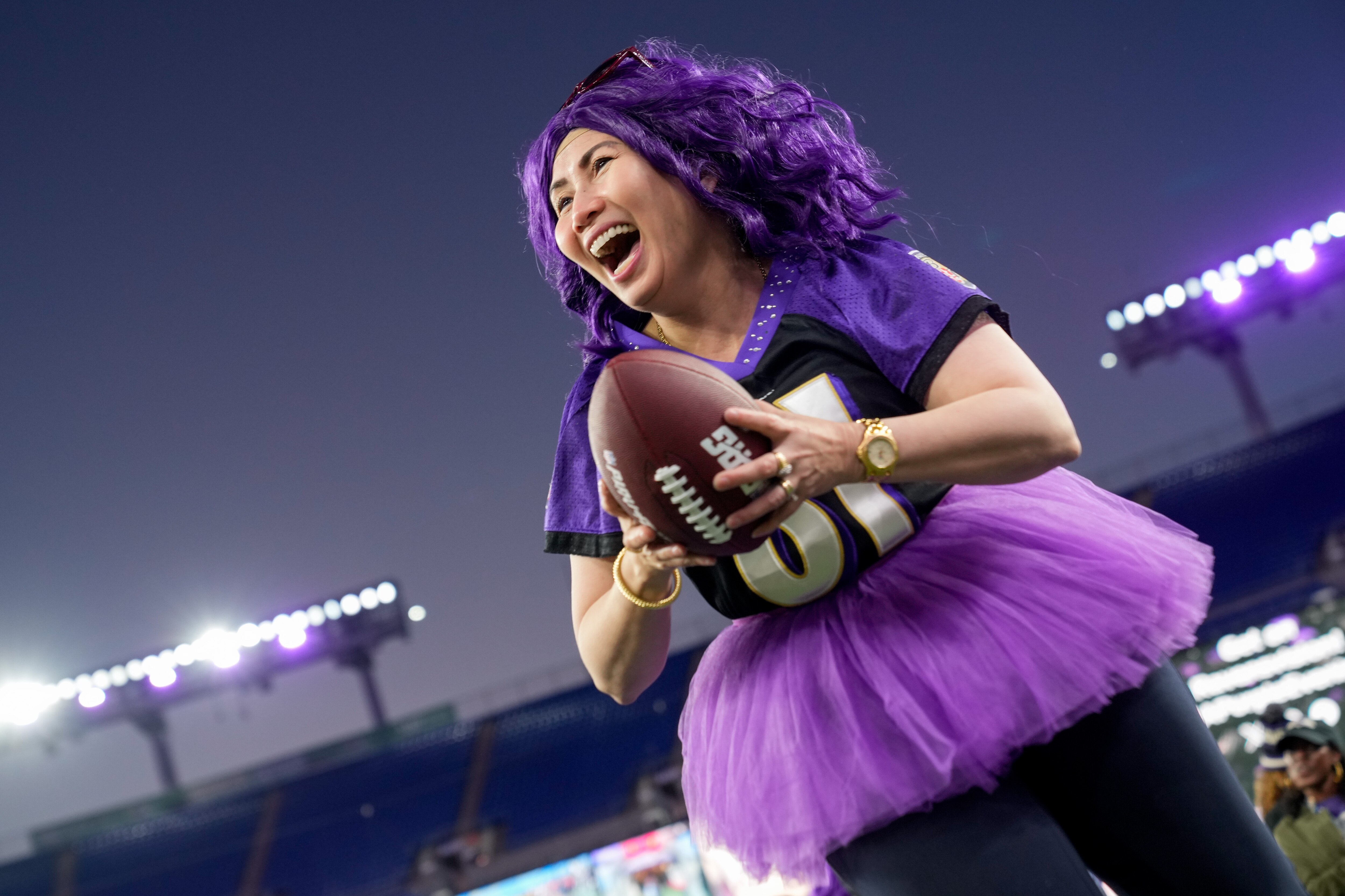 Jinky Date laughs as she sprints through a football drill at A Purple Evening, the Baltimore Ravens’s annual women’s event, at M&T Bank Stadium in Baltimore on Monday, October 14, 2024.
