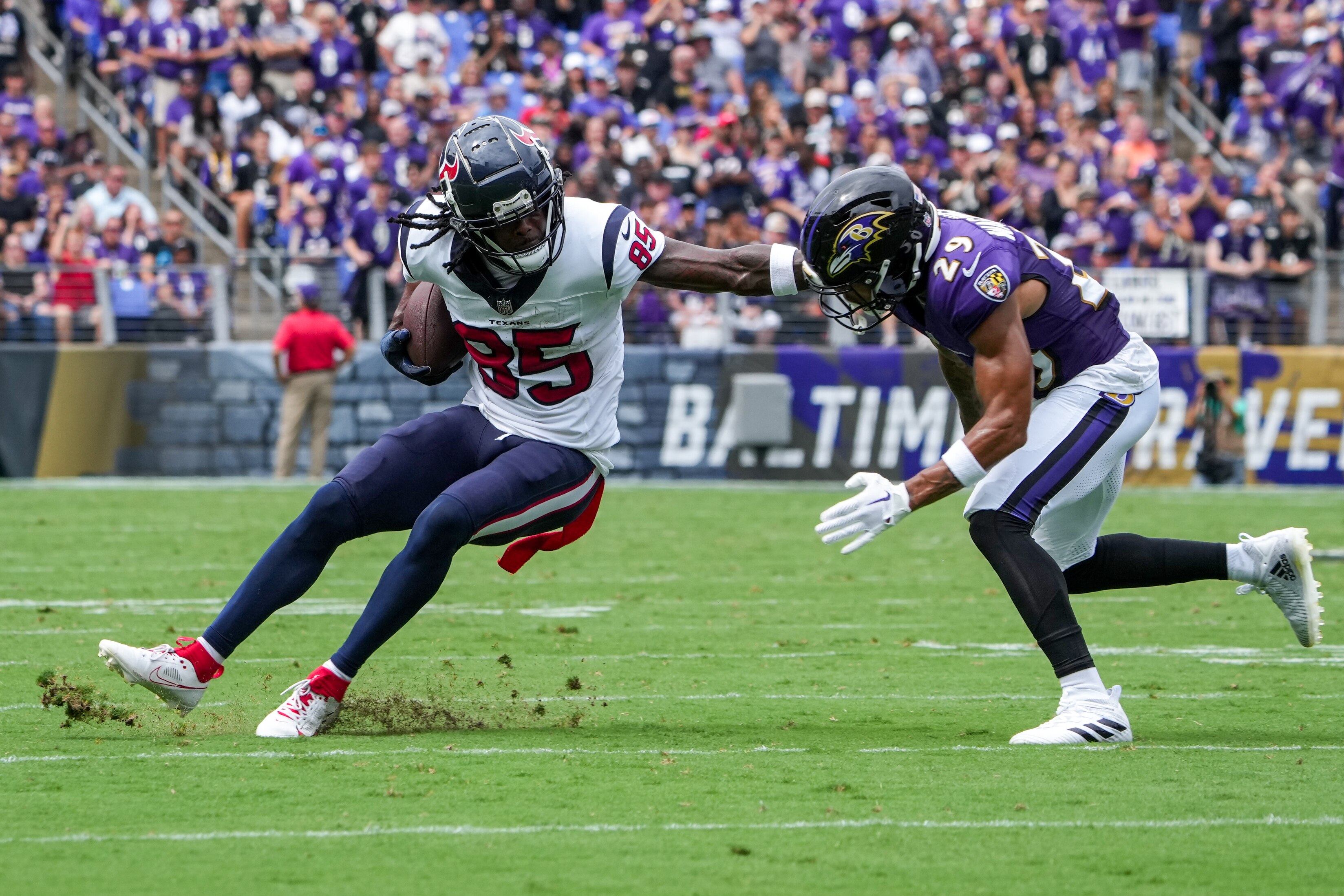 Houston Texans wide receiver Noah Brown (85) stiff arms Baltimore Ravens safety Ar'Darius Washington (29) in their opening game of the season at M&T Bank Stadium on Sunday, September 10, 2023.
