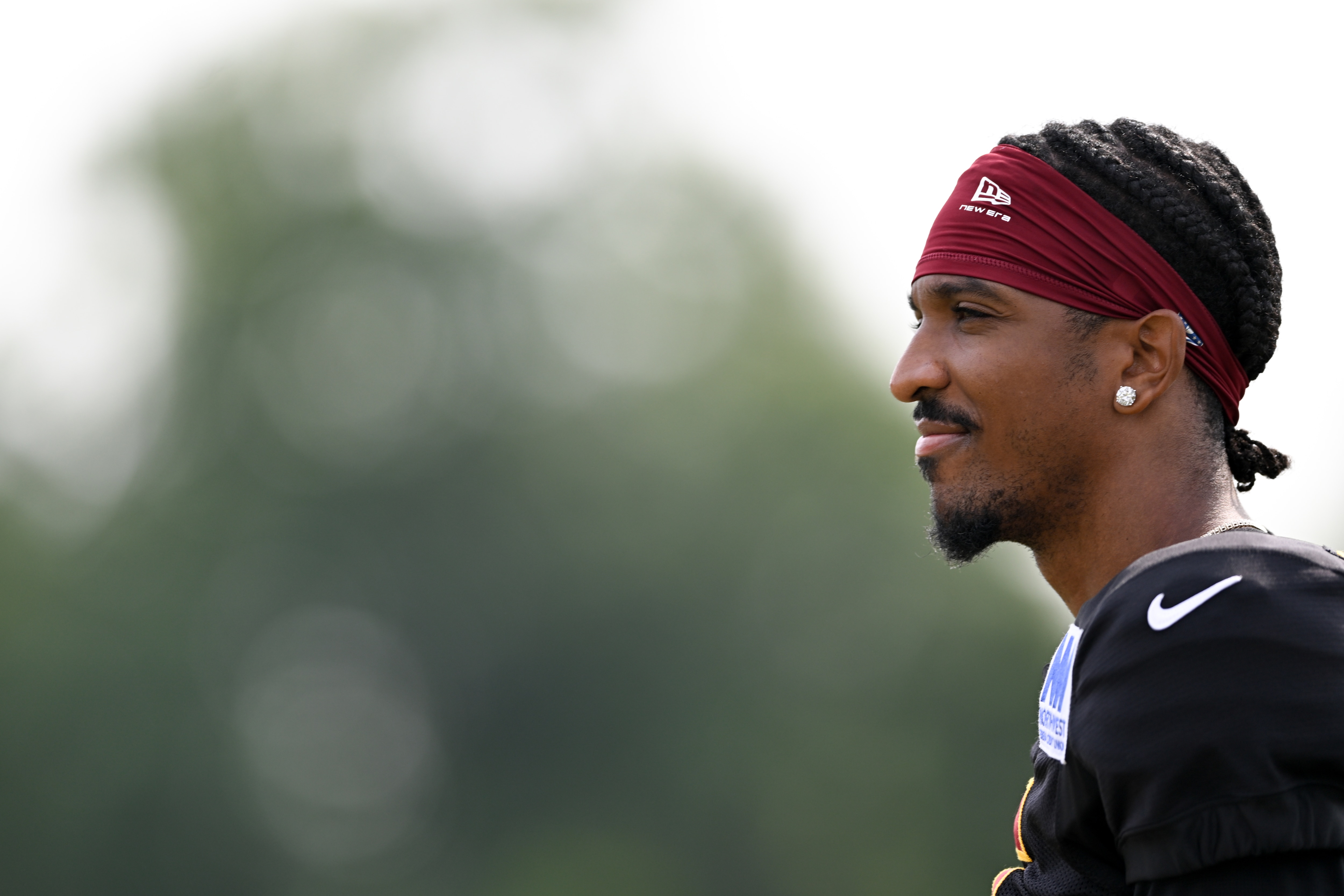 Washington Commanders quarterback Jayden Daniels looks on during training camp practice on Aug. 12.