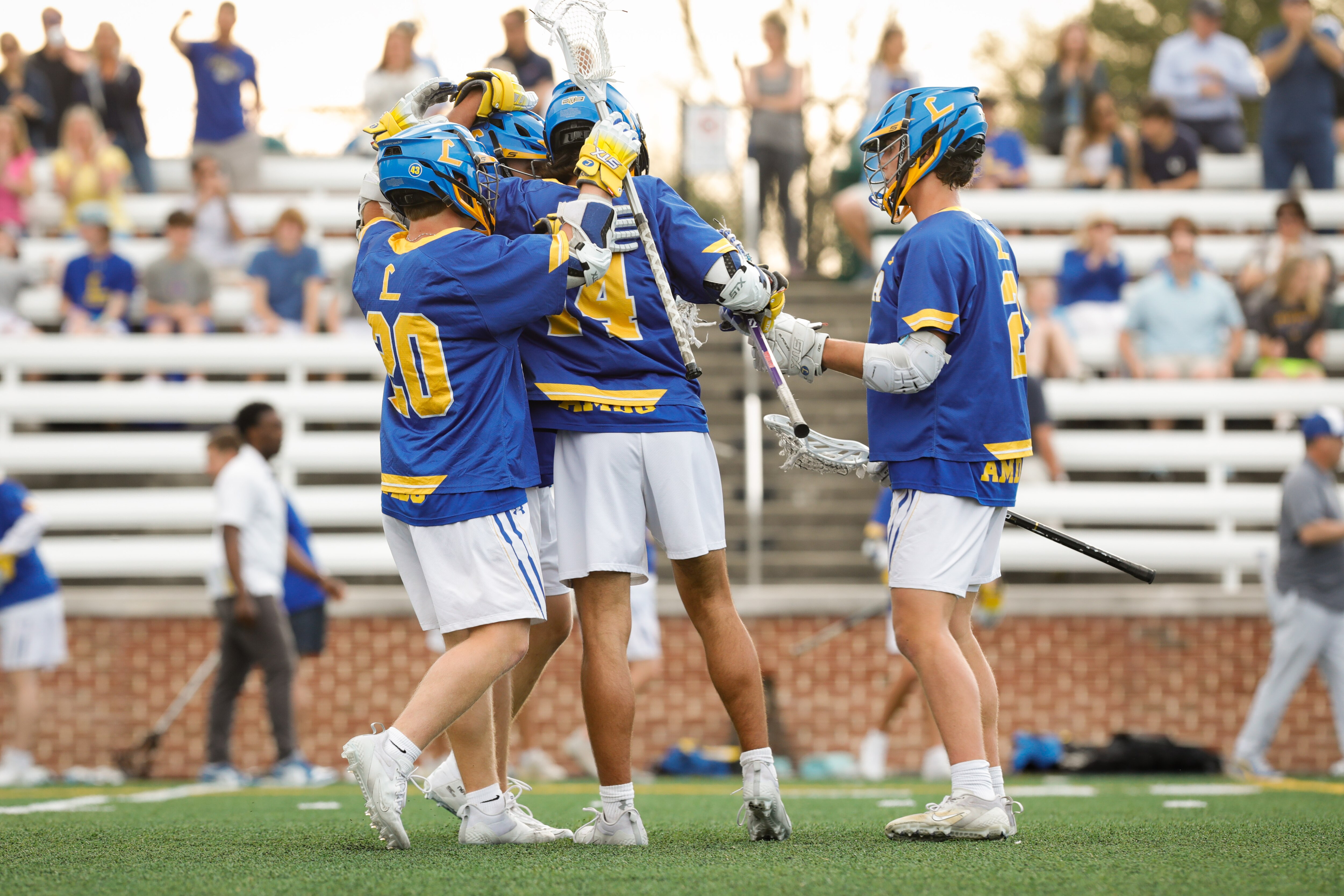 Mason Cook (center) celebrates with his Loyola teammates after his fourth quarter goal Tuesday against St. Paul's. The No. 3 Dons scored the final 5 goals in regulation to claim an 11-9 victory over sixth-ranked St. Paul's in MIAA A lacrosse battle in Brooklandville.