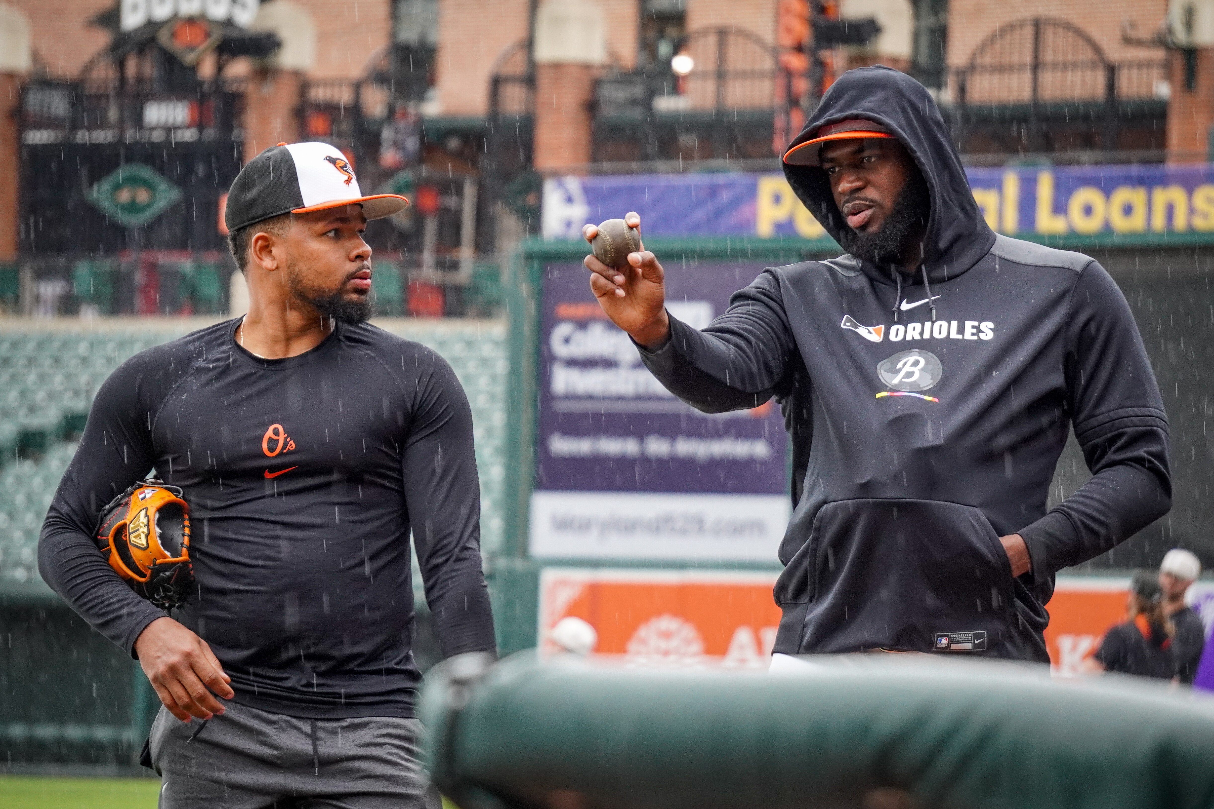 Orioles closer Félix Bautista demonstrates a pitch grip to fellow reliever Yaramil Hiraldo on Tuesday at Camden Yards.