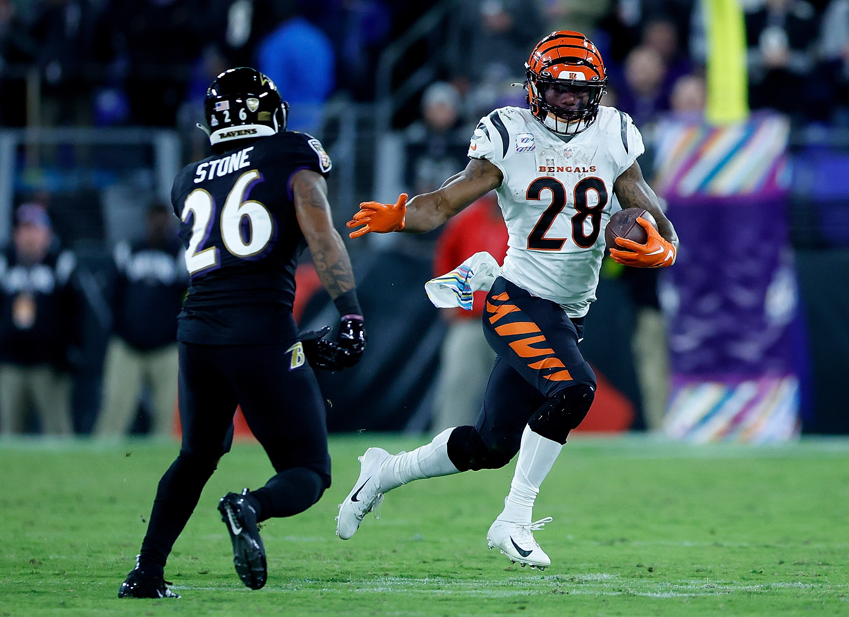BALTIMORE, MARYLAND - OCTOBER 09:  Joe Mixon #28 of the Cincinnati Bengals rushes against Geno Stone #26 of the Baltimore Ravens in the fourth quarter at M&T Bank Stadium on October 09, 2022 in Baltimore, Maryland.