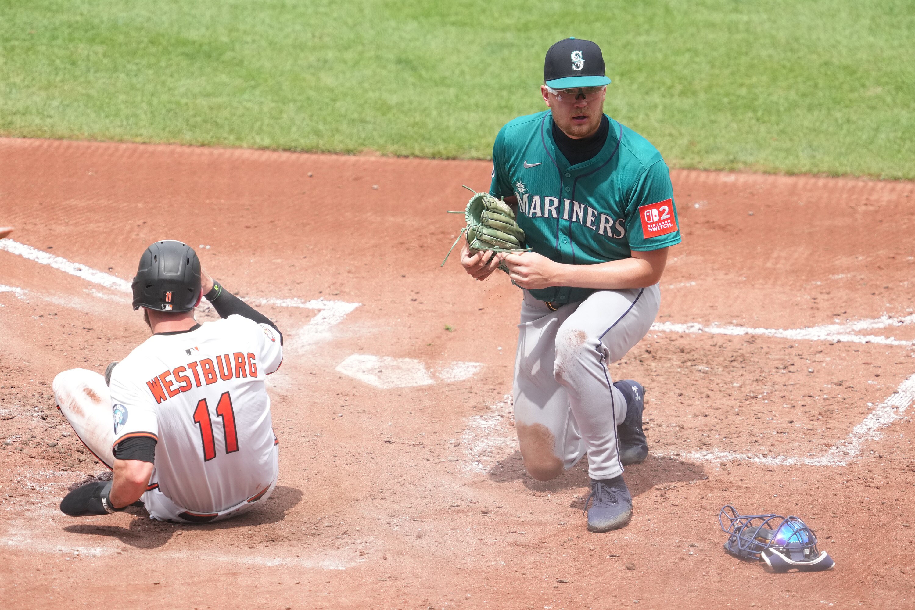 Jordan Westburg beats the tag of Mariners pitcher Logan Evans to score on a wild pitch in the fourth inning.