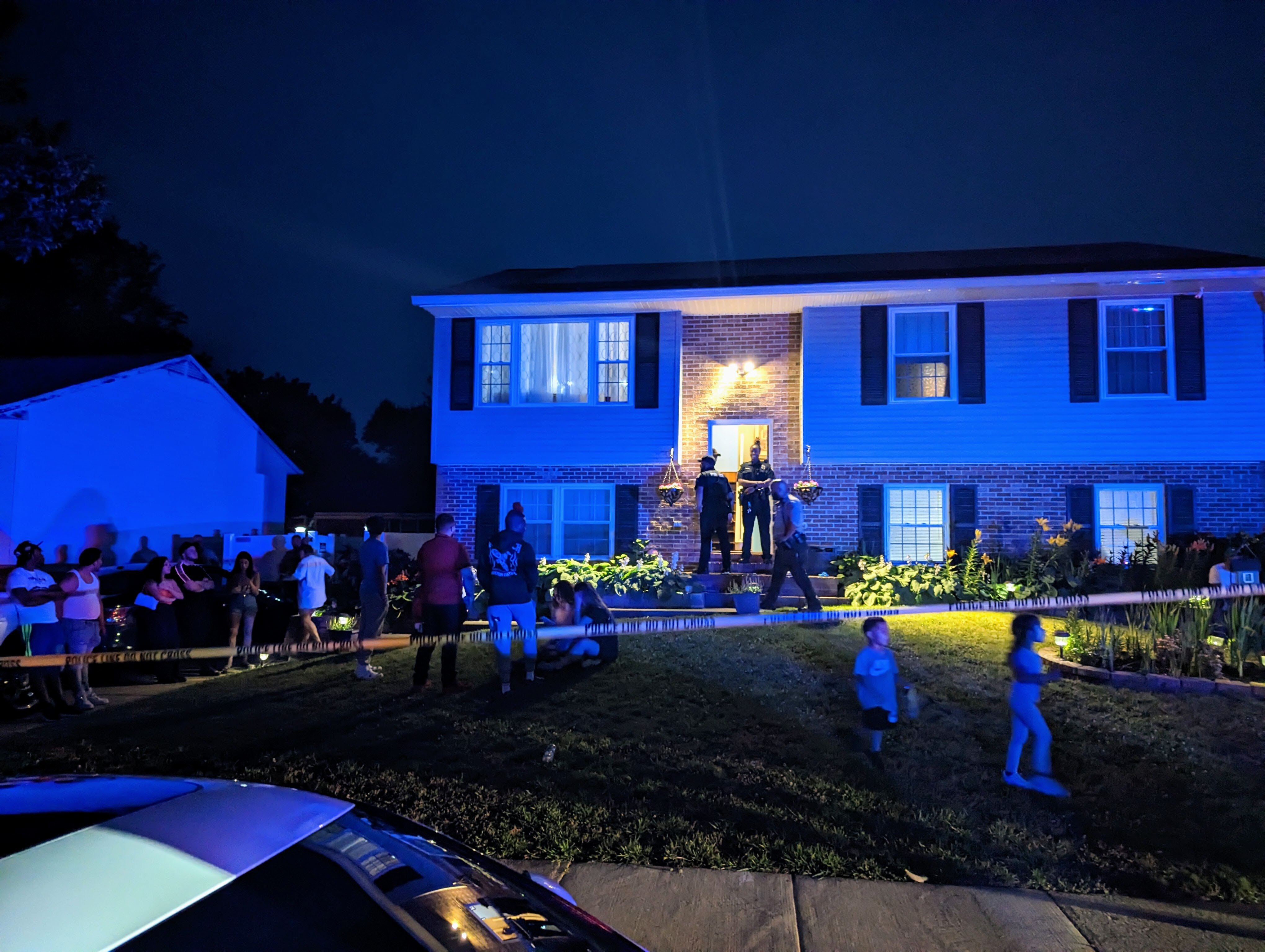A police officer stands outside the home on Paddington Place in Annapolis were neighbors say a house party Sunday night ended with three people dead after a dispute with a man who lived nearby.