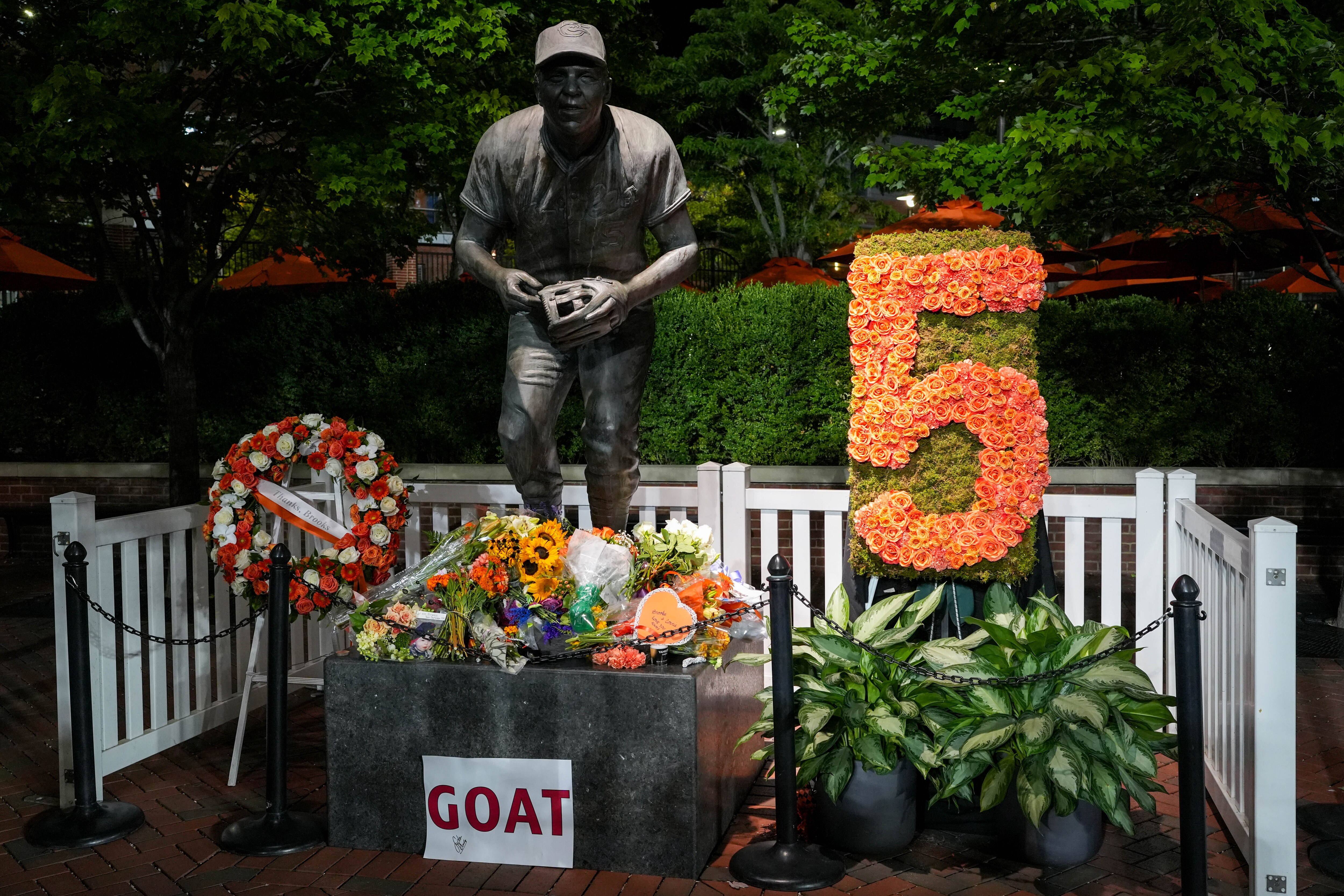 A statue of Baltimore Orioles legend Brooks Robinson is seen decorated with flowers honoring his life and career on Wednesday, Sept. 27, 2023, after his family announced his death the previous night. Robinson died at age 86.