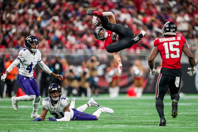 Atlanta Falcons wide receiver Drake London (5) flips over Baltimore Ravens safety Jaylinn Hawkins (21)