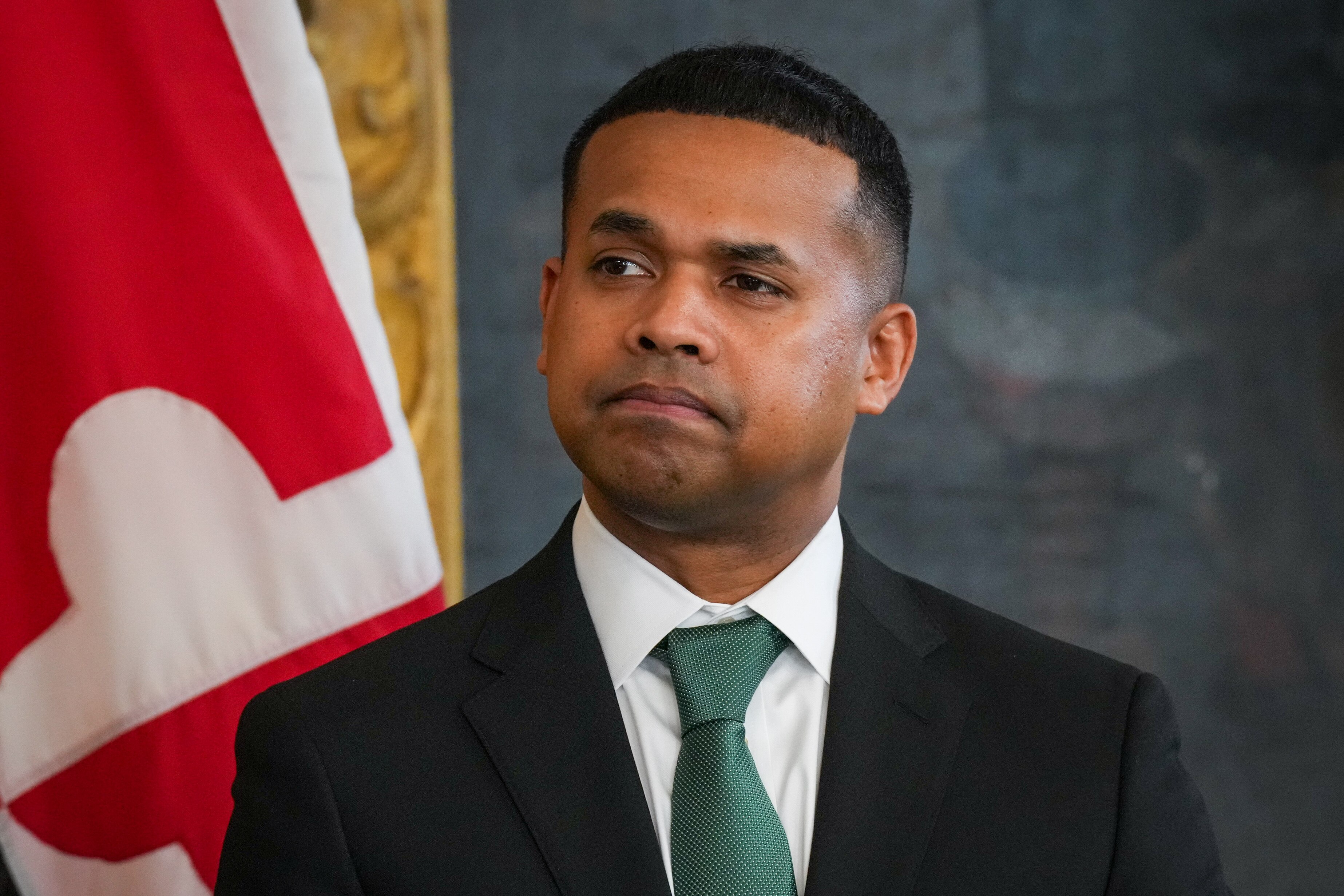 Paul Monteiro listens to Gov. Wes Moore announce him as his pick to serve as the first secretary of the Department of Service and Civic Innovation at a press conference in the Maryland State House on Monday, April 3. Moore issued an executive order creating the cabinet-level department on his first full day in office in January.
