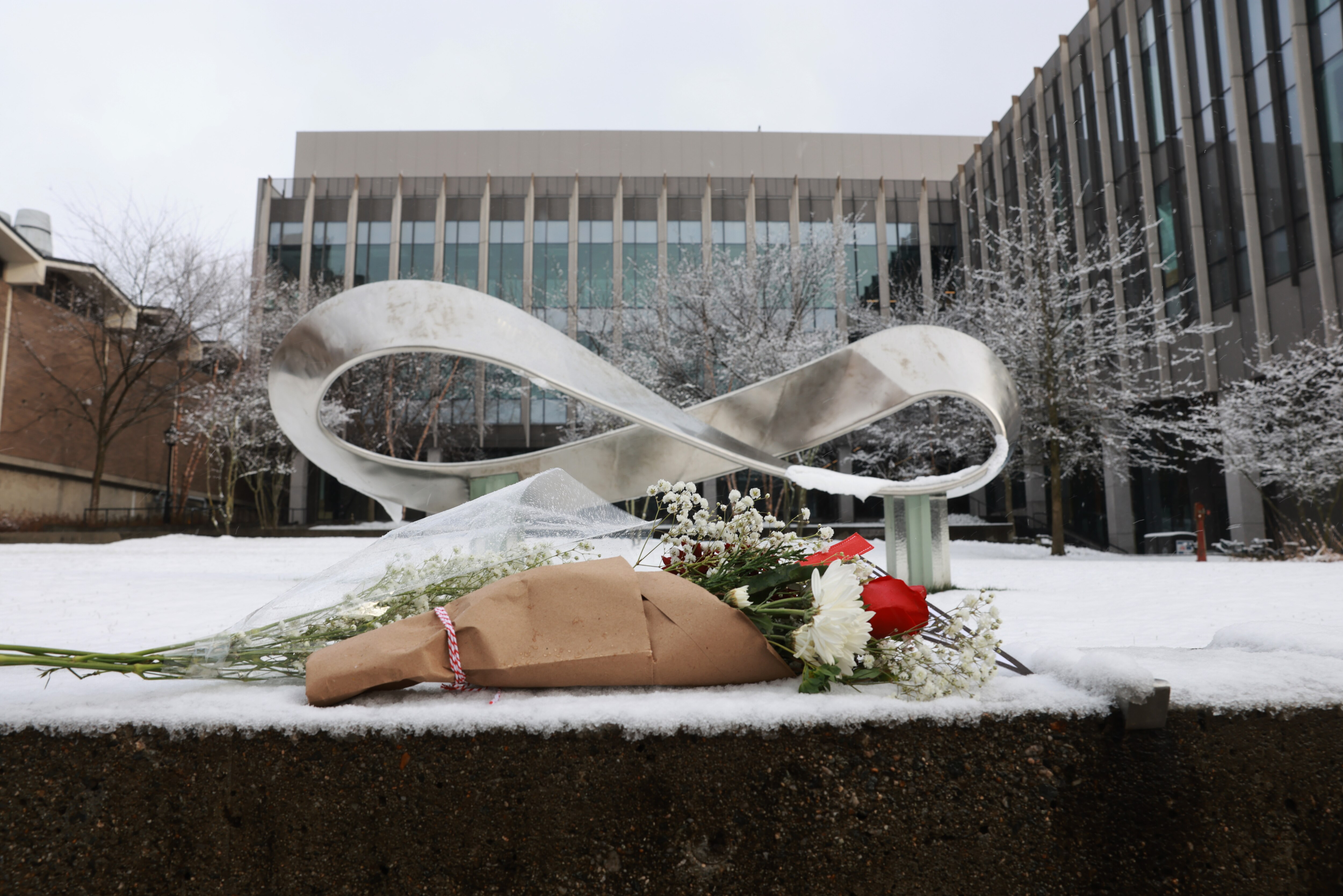 A bouquet is left outside of the engineering and physics building at Brown University, the site of a mass shooting last weekend that left two people dead and nine others injured, on December 14, 2025, in Providence, Rhode Island. A suspect in the shooting and a killing in Massachusetts was found dead in a New Hampshire storage facility.