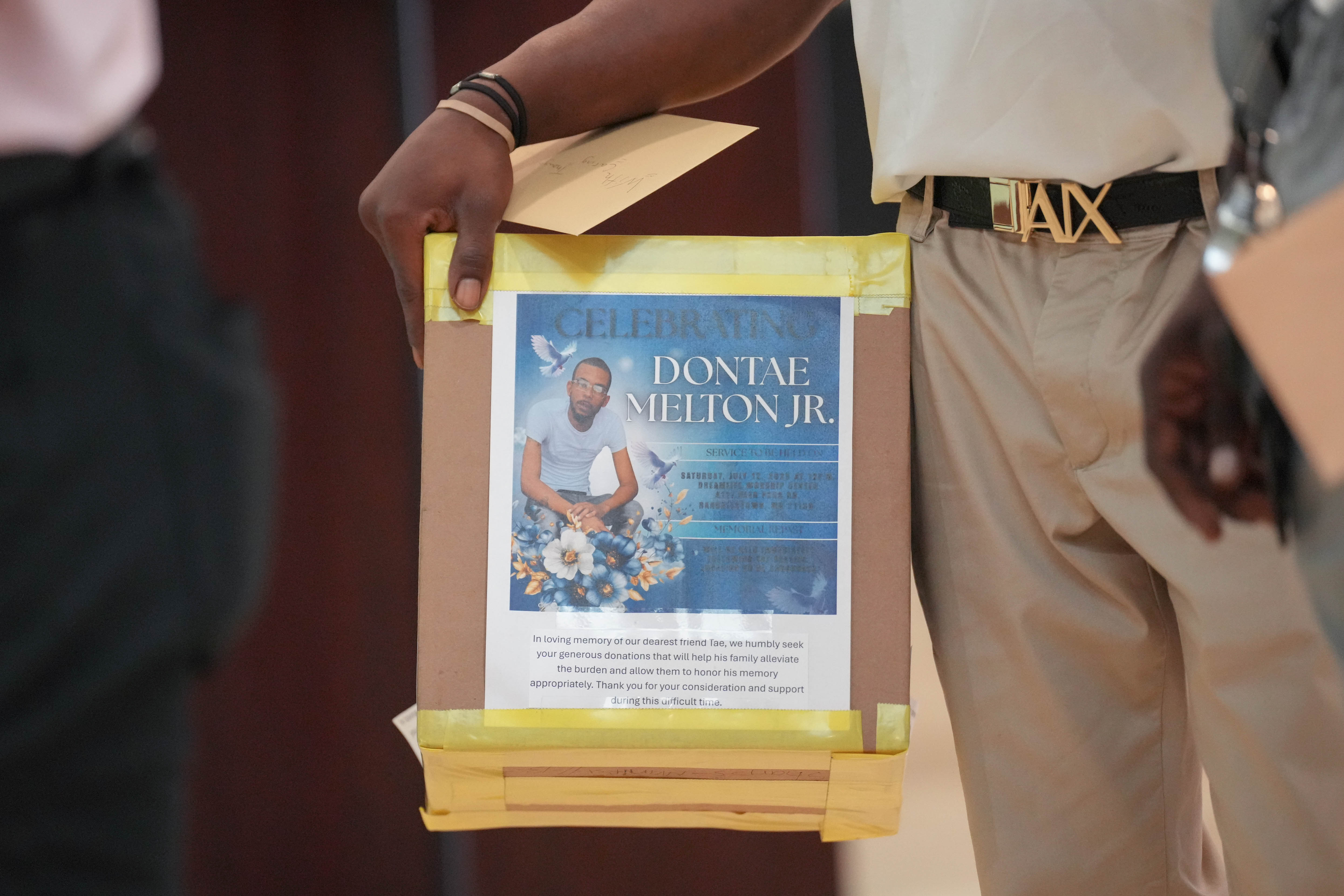 A co-worker of Dontae Melton Jr. brings a box of donations from his colleagues to Melton’s funeral at DreamLife Worship Center in Randallstown on Saturday.