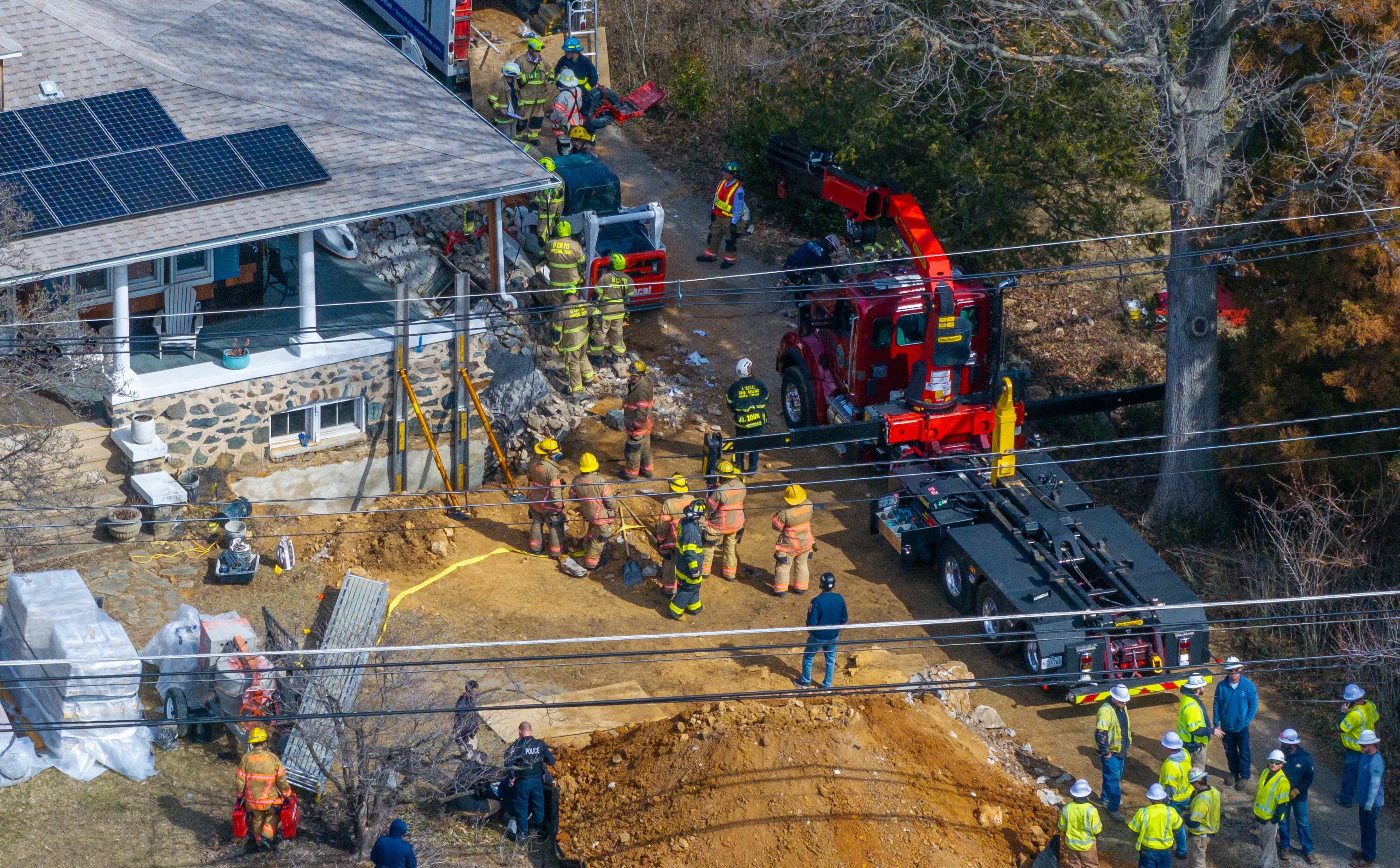 First responders attempt to rescue trapped construction workers on Academy Road in Catonsville on Friday.