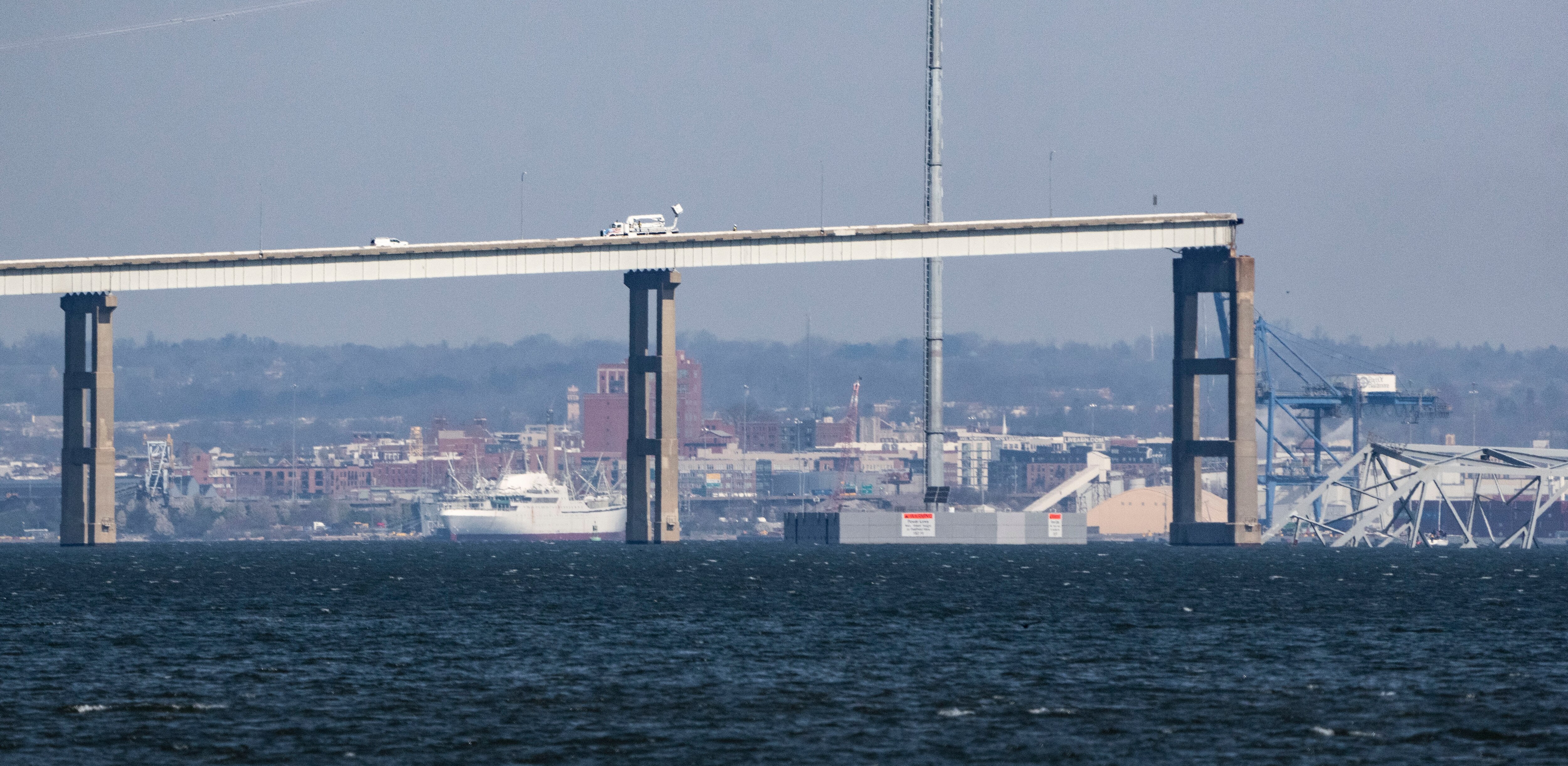 The closure of the Port of Baltimore following the collapse of the Francis Scott Key Bridge has left crews from seven ships stuck on board their vessels. Photo of remaining section of bridge taken on March 29, 2024.