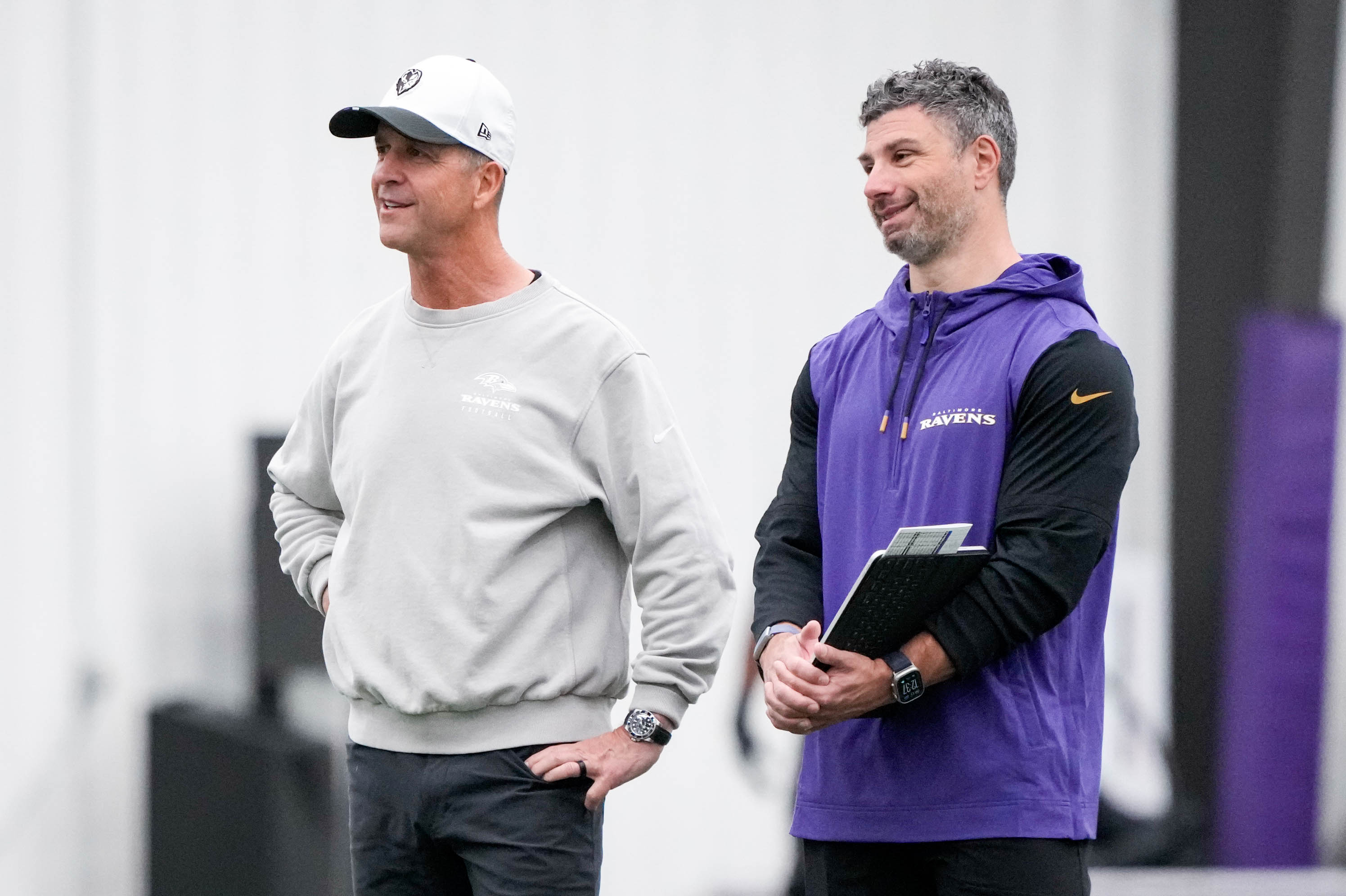 Ravens coach John Harbaugh, left, watches the team’s first organized team activity session of the year Wednesday.
