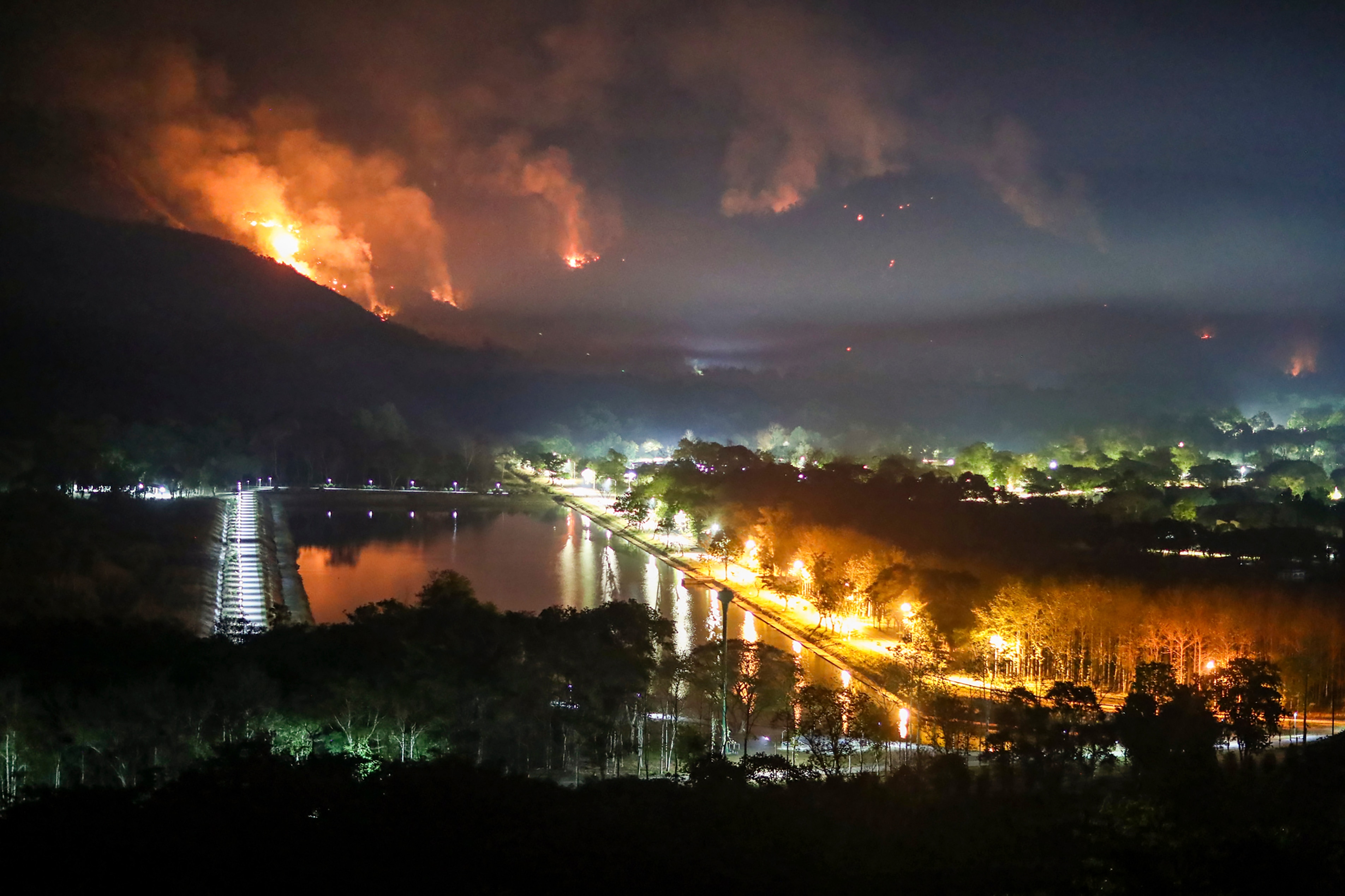 Fire and smoke rise from a forest fire at Nakhon Nayok province province, 114 kilometers (70 miles) northeast of Bangkok. Thailand, Thursday, March 30, 2023. The fire had engulfed large areas of two mountains by Thursday, and the authorities were trying to contain its spread.