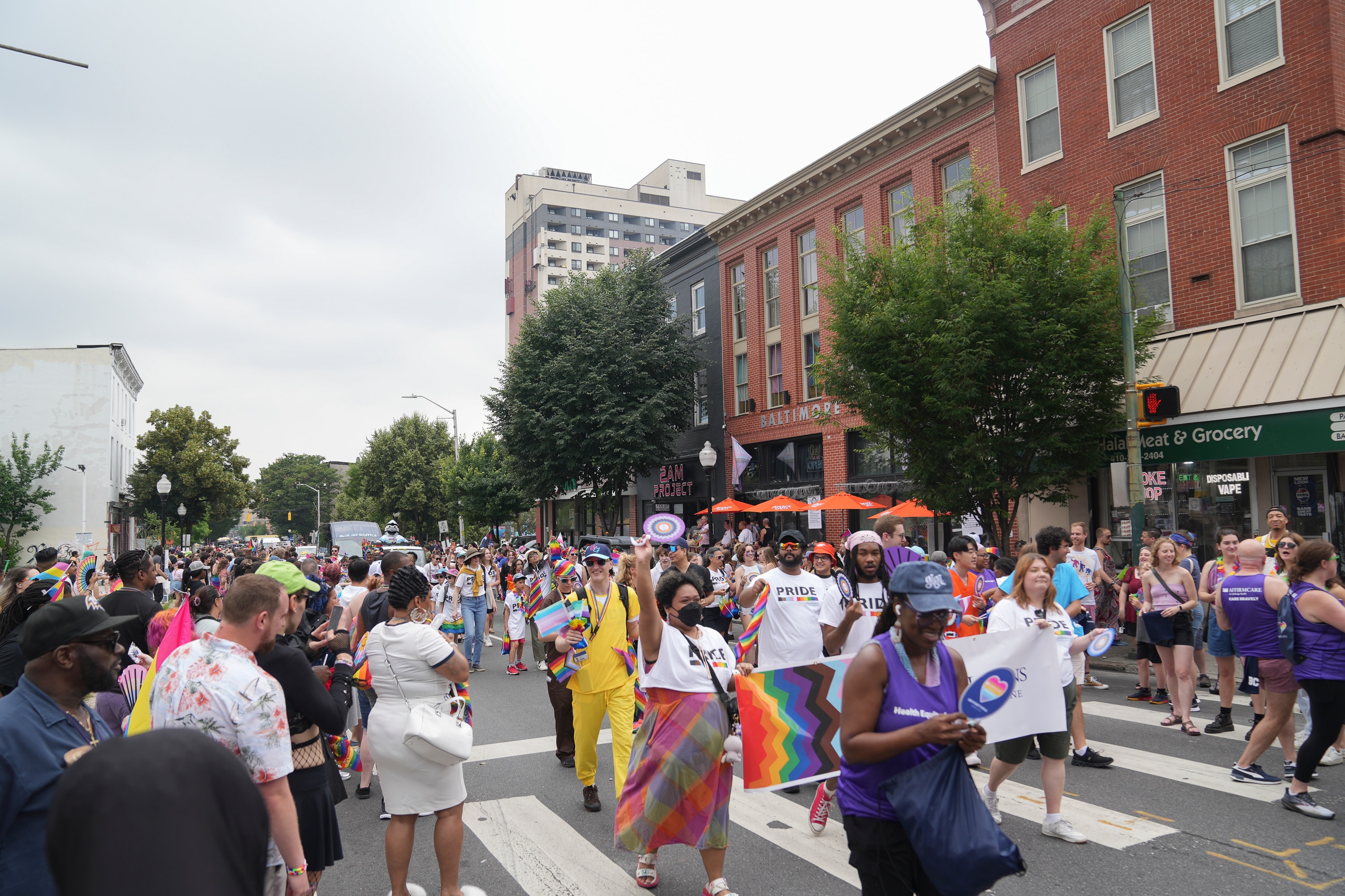The crowd on the sidelines smile and take photos as the parade goes underway at the 50th annual Baltimore Pride celebration in the Charles Village neighborhood of Baltimore on June 14, 2025.