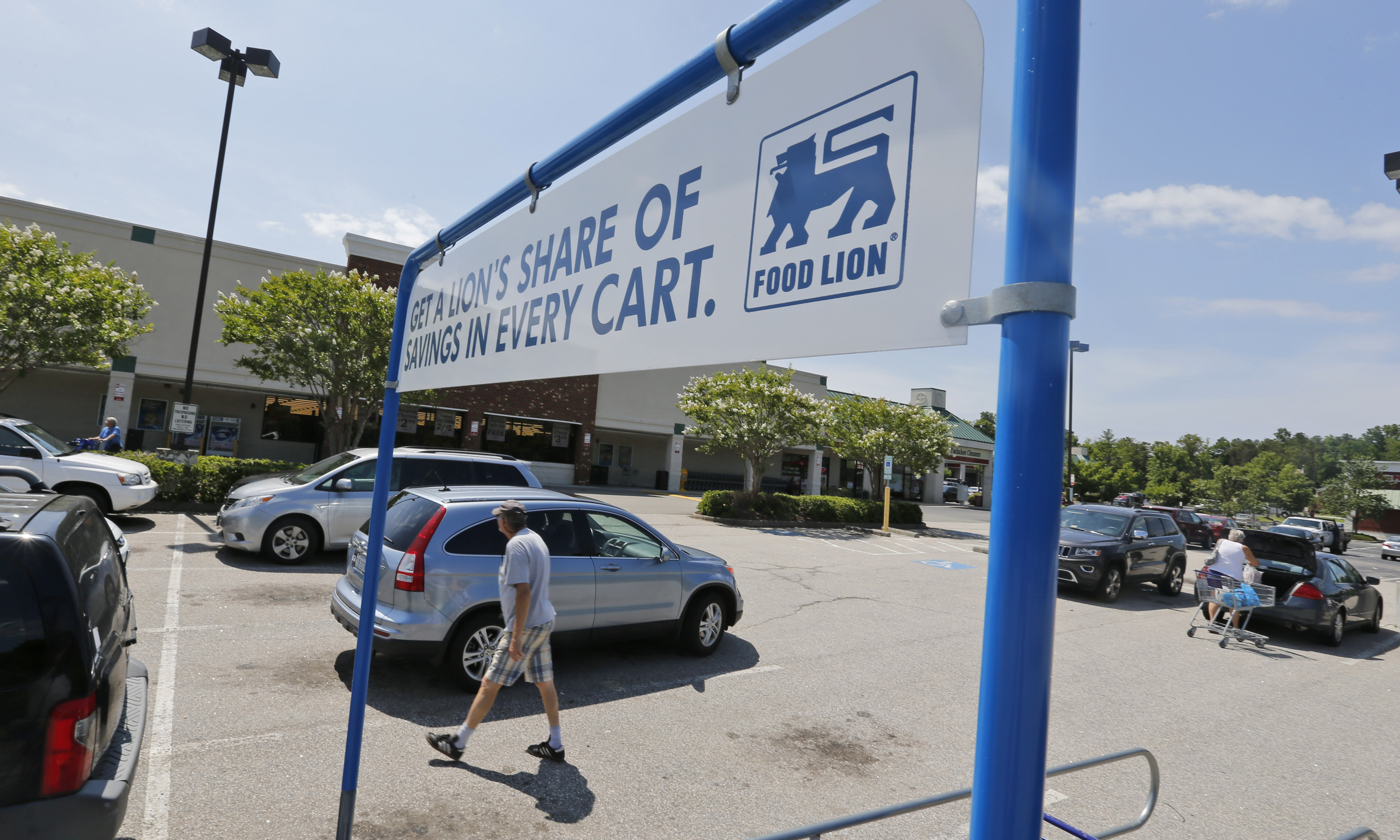 Shoppers walk in the parking lot at a Food Lion grocery store in Richmond, Va., Wednesday, June 24, 2015.  Dutch retailer Royal Ahold NV, which operates U.S. supermarket chains Stop & Shop and Giant, has agreed to merge with its Belgian counterpart Delhaize Group, which operates the Hannaford and Food Lion stores in the eastern United States. (AP Photo/Steve Helber)