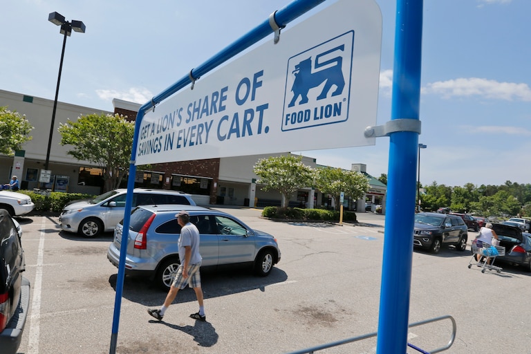 Shoppers walk in the parking lot at a Food Lion grocery store in Richmond, Va., Wednesday, June 24, 2015. Dutch retailer Royal Ahold NV, which operates U.S. supermarket chains Stop & Shop and Giant, has agreed to merge with its Belgian counterpart Delhaize Group, which operates the Hannaford and Food Lion stores in the eastern United States. (AP Photo/Steve Helber)