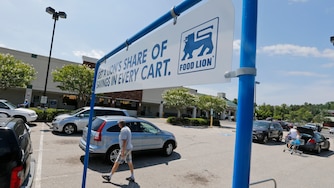 Shoppers walk in the parking lot at a Food Lion grocery store in Richmond, Va., Wednesday, June 24, 2015. Dutch retailer Royal Ahold NV, which operates U.S. supermarket chains Stop & Shop and Giant, has agreed to merge with its Belgian counterpart Delhaize Group, which operates the Hannaford and Food Lion stores in the eastern United States. (AP Photo/Steve Helber)