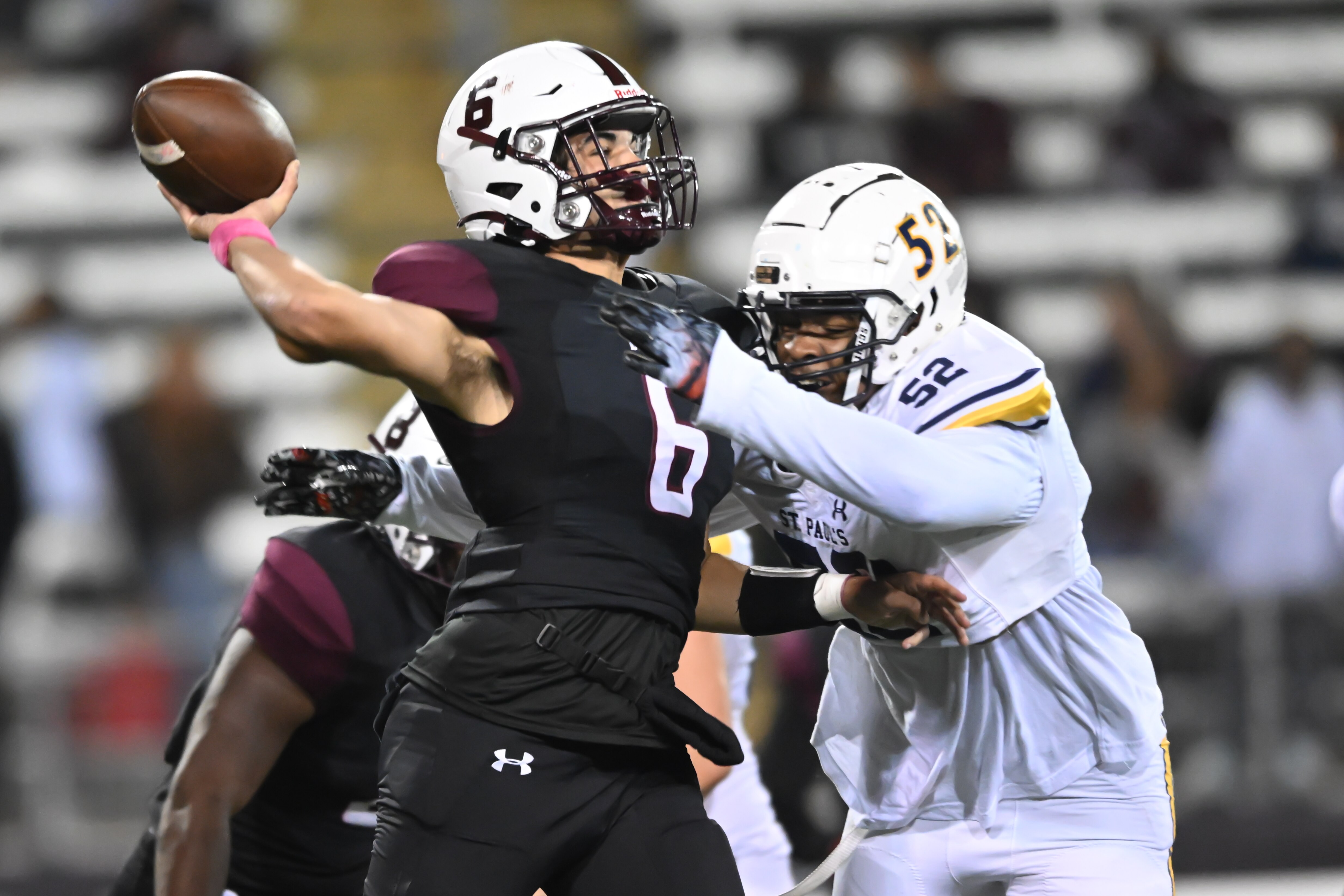 Boys' Latin quarterback Jackson Field (6) prepares to throw the football as St. Paul's Cidney Johnson (52) closes in. The Lakers scored the final 22 points in regulation to take a 42-24 decision over the Crusaders at Towson University's Johnny Unitas Stadium.