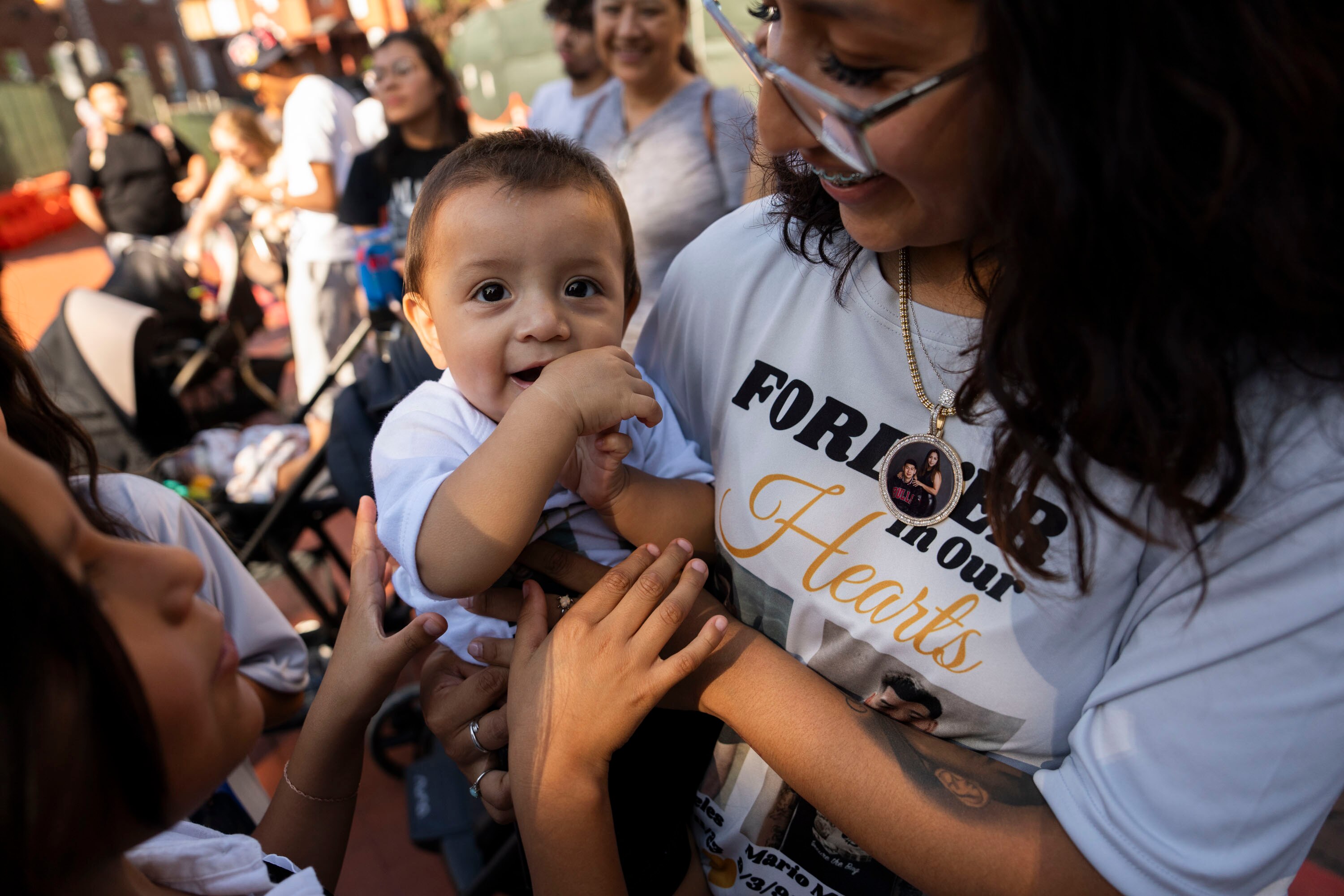 Sebastian Mario, son of Mario Mireles Ruiz, is held by his mother Judy on the one-year anniversary of his father’s death.