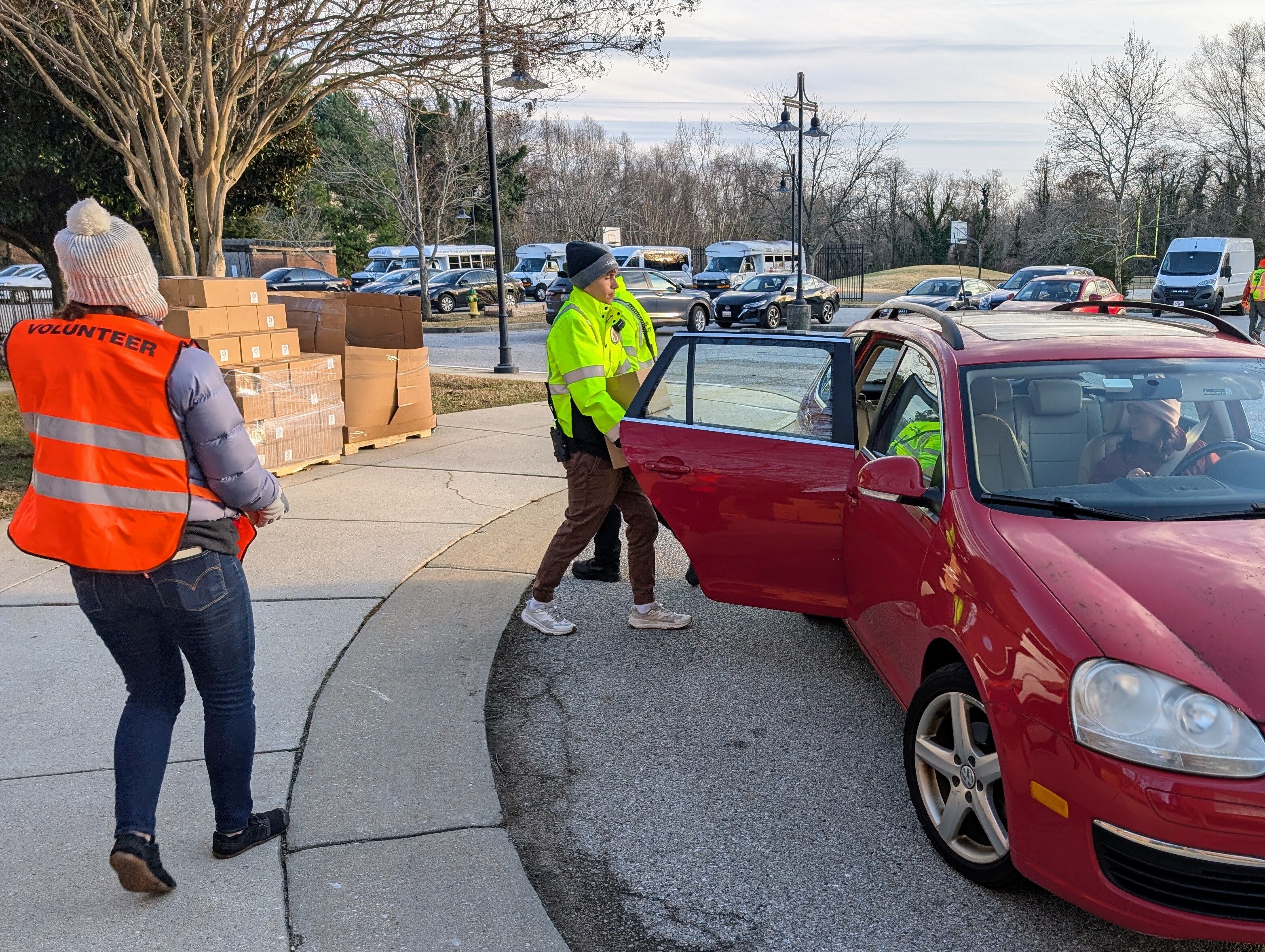 Volunteers put canned goods and fresh produce into the backseat of a car at a food relief distribution on Dec. 4, 2025 in Annapolis.