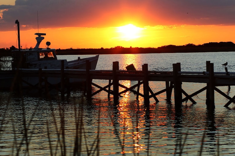 EWELL, MD - AUGUST 22: The sun sets behind a fishing boat on August 22, 2011 in Ewell, Smith Island, Maryland. on August 22, 2011 in Ewell, Smith Island, Maryland.