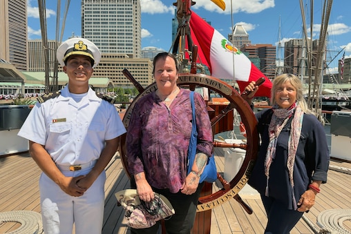 Betsy Bowen (right side) and Shay Seaborne (in center) standing at the helm of the B.A.P. Union ship with midshipman Joshua Aponte.