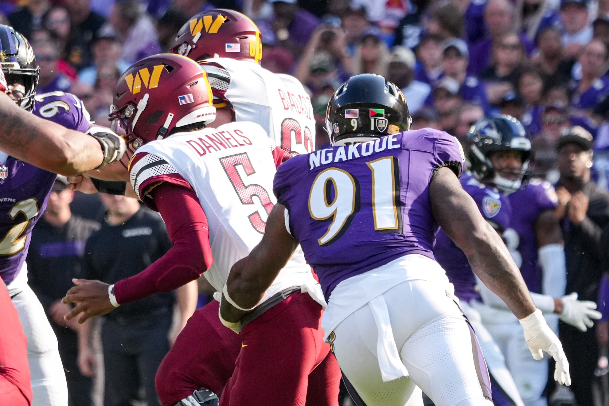 Defensive end Yannick Ngakoue (91) rushes Washington Commanders quarterback Jayden Daniels (5).