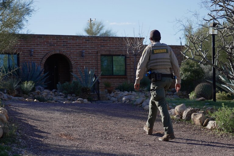 A member of the Pima County sheriffs office remains outside of Nancy Guthrie's home, Monday, Feb. 9, 2026 in Tucson, Ariz.