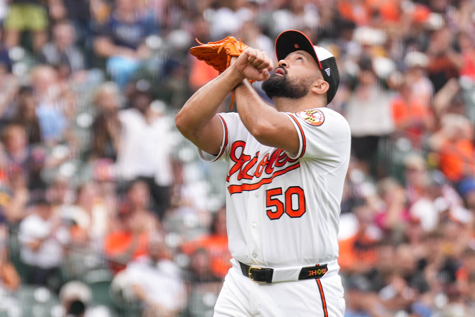 Orioles pitcher Rico Garcia crosses his arms to the sky, a gesture in honor of his grandfather, after throwing a scoreless 10th inning against the Tampa Bay Rays on May 25.