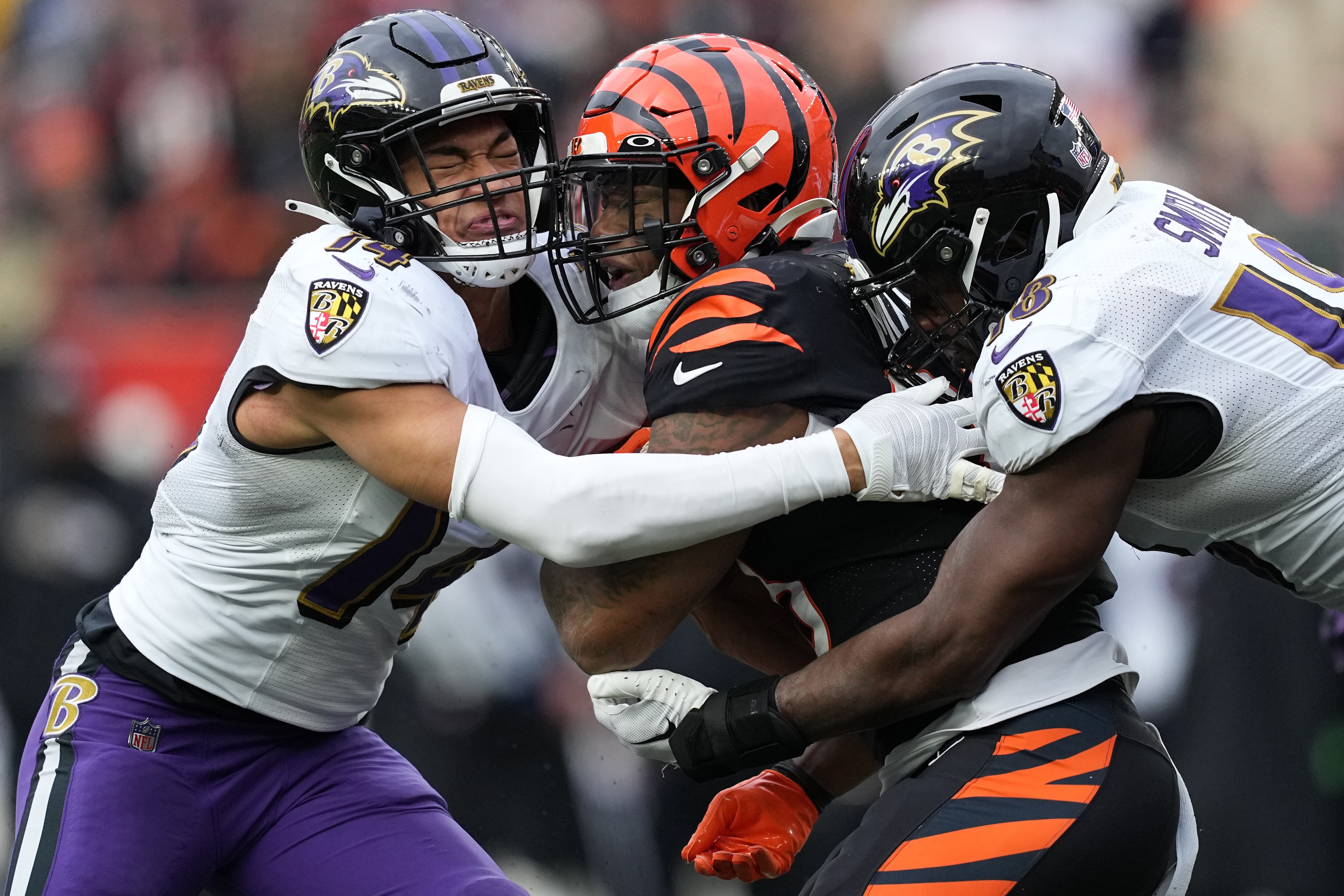 CINCINNATI, OHIO - JANUARY 08: Kyle Hamilton #14 and Roquan Smith #18 of the Baltimore Ravens tackle Joe Mixon #28 of the Cincinnati Bengals during the second quarter at Paycor Stadium on January 08, 2023 in Cincinnati, Ohio. (Photo by Dylan Buell/Getty Images)