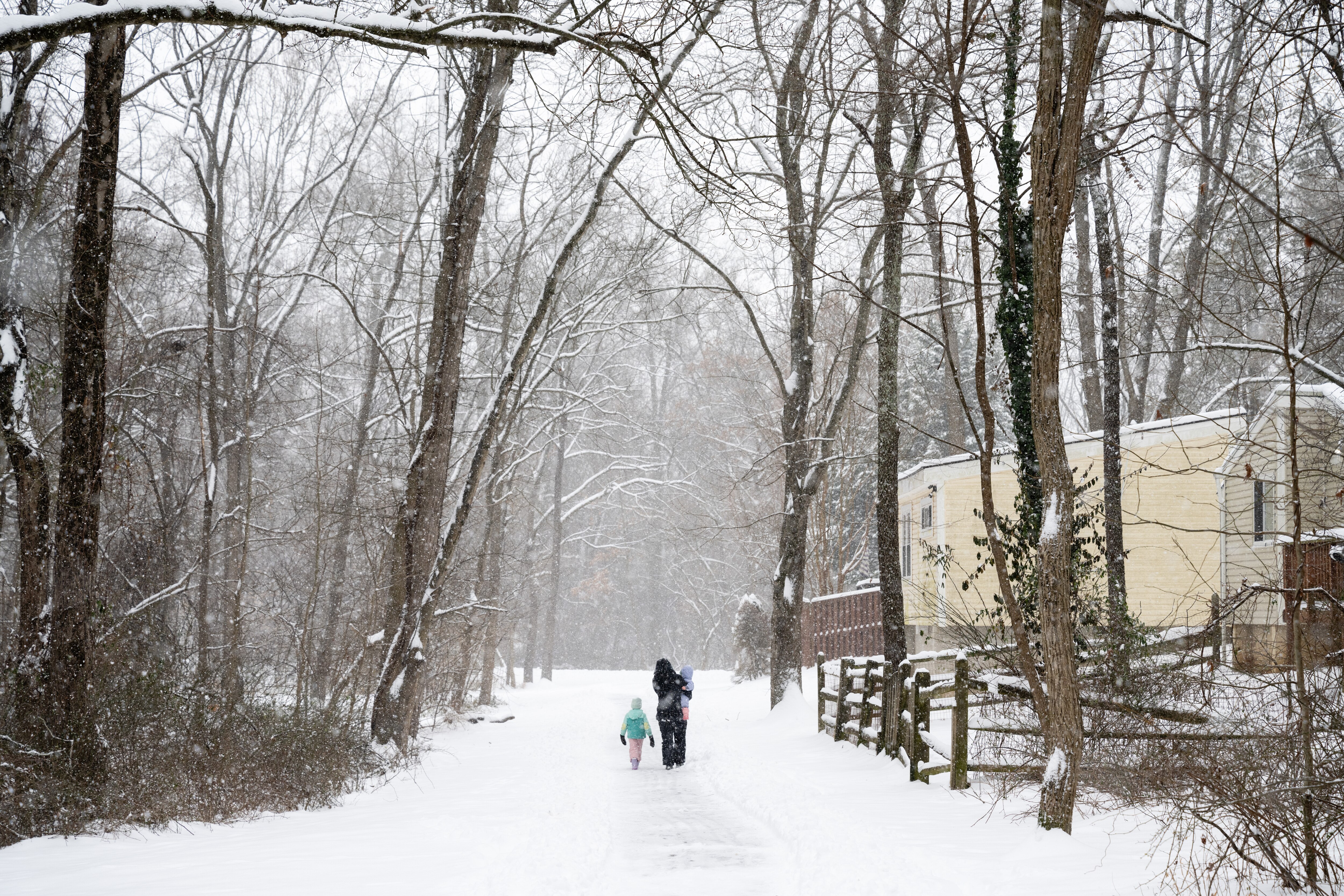 A family walks along a snowy path in Columbia, MD on January 6th, 2025.