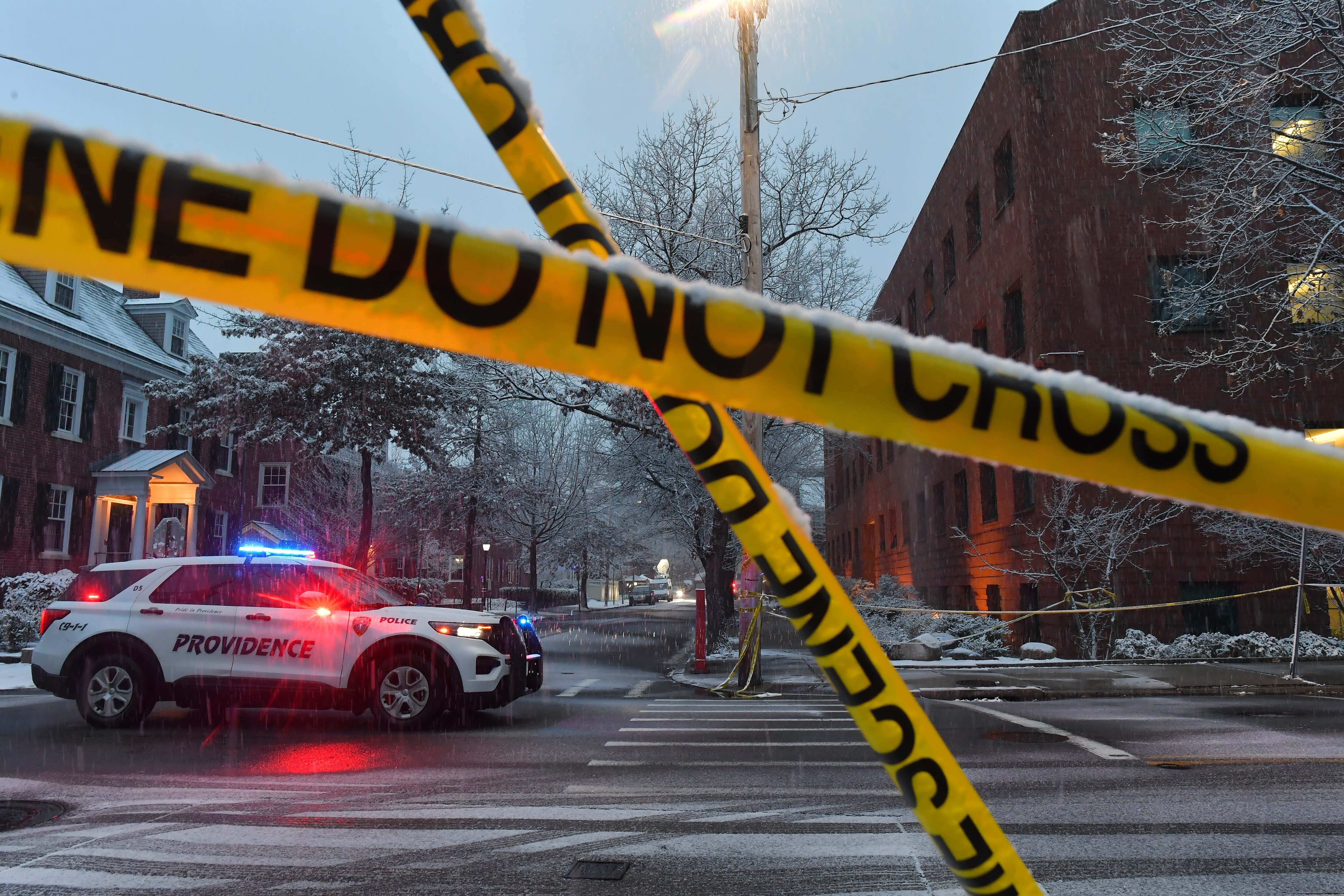 A police vehicle rests at an intersection near crime scene tape at Brown University.