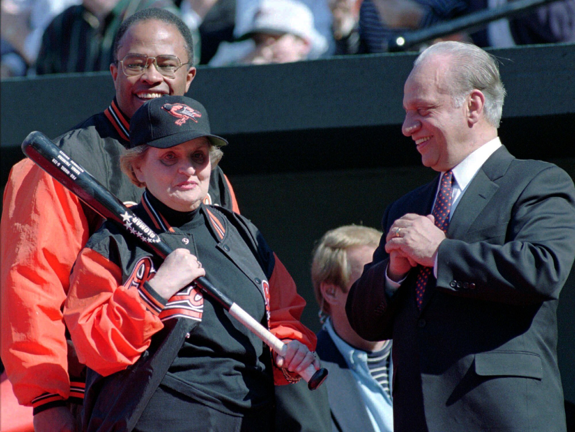 Secretary of State Madeleine Albright clutches a bat as she stands with Orioles owner Peter Angelos, right, and Baltimore Mayor Kurt Schmoke at Camden Yards in 1997 during season-opening ceremonies.