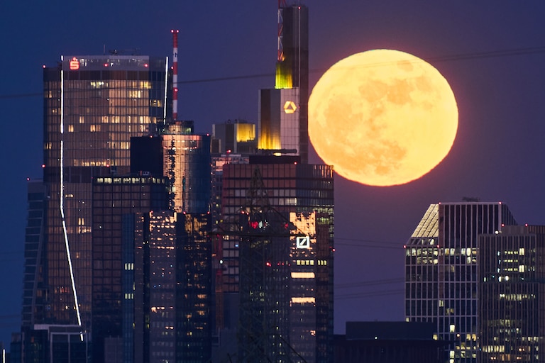 The full moon rises behind the buildings of the banking district in Frankfurt, Germany, Friday, May 1, 2026. (AP Photo/Michael Probst)
