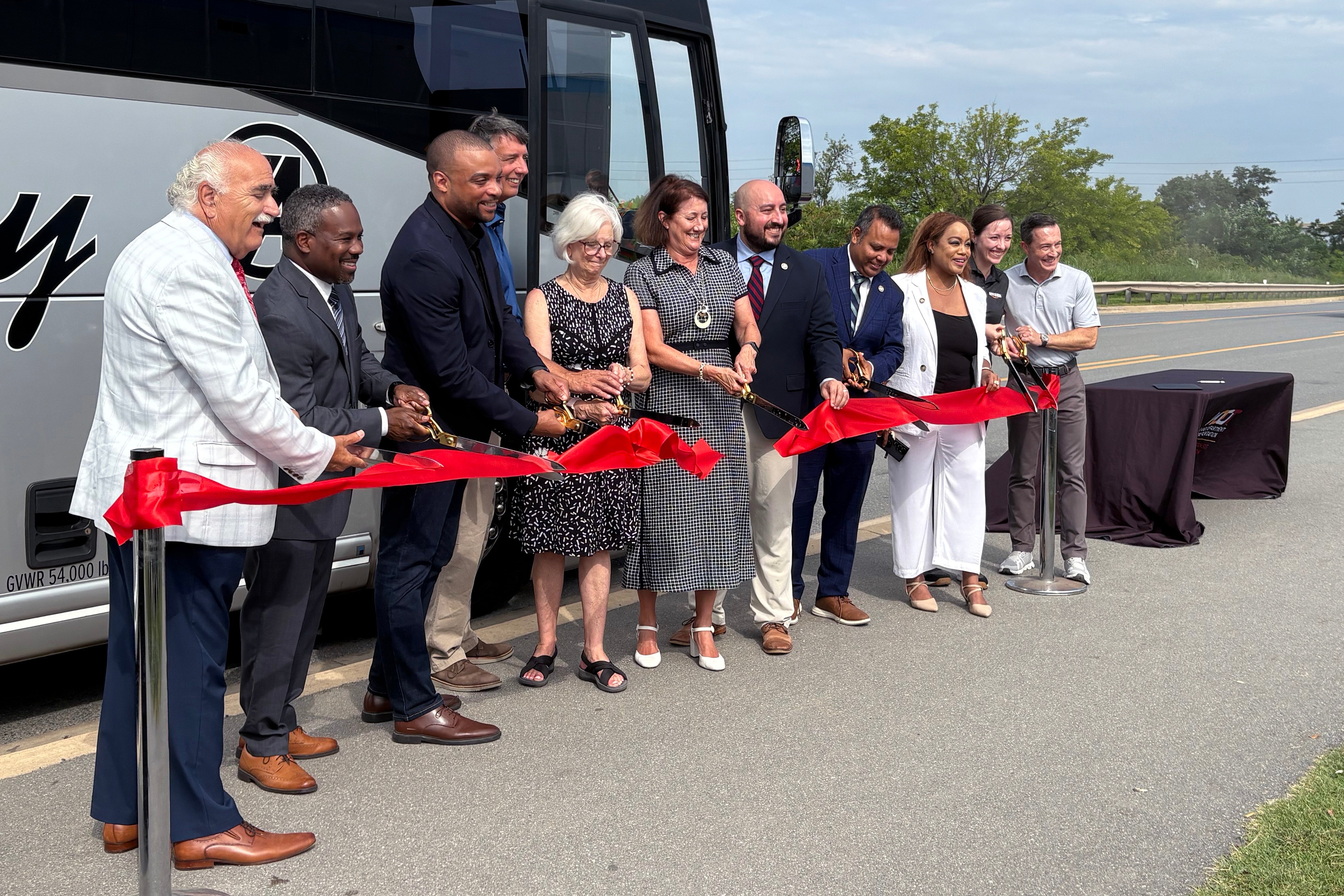 Delegates, senators, state officials, and Tradepoint representatives cut the ribbon on the new 411T commuter bus.